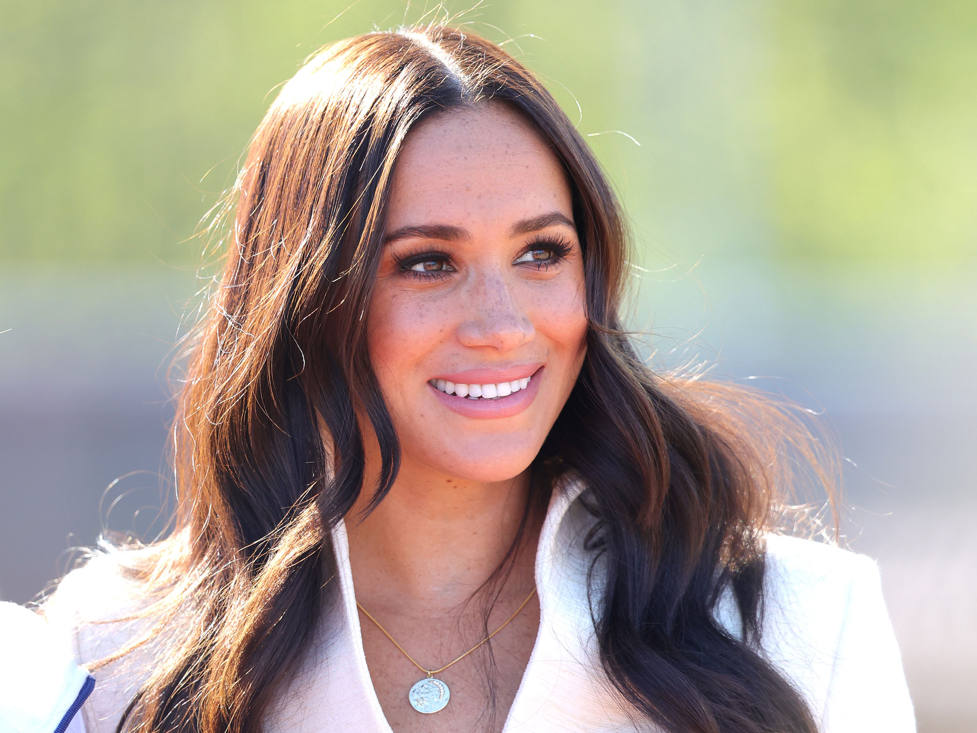 Meghan Markle smiles and looks away from the camera