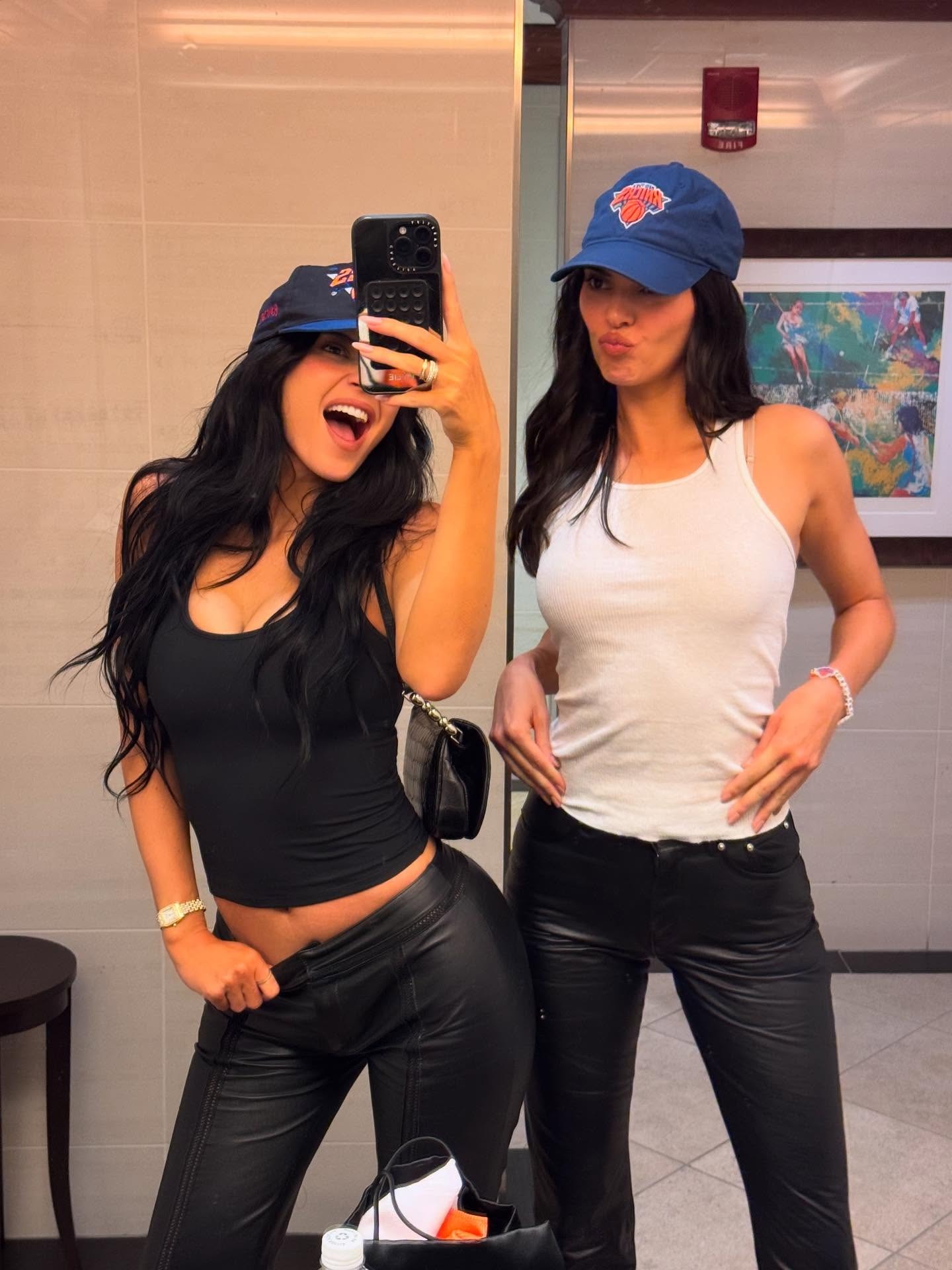 Kylie and kendall jenner wear tank tops, knicks hats, and leather pants.