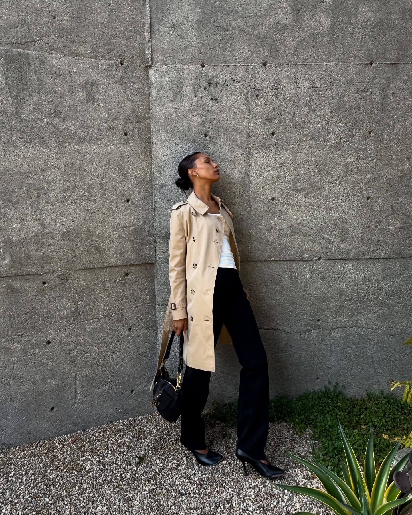 Jasmine Tookes wearing a Burberry trench coat, white tee, and black pants.