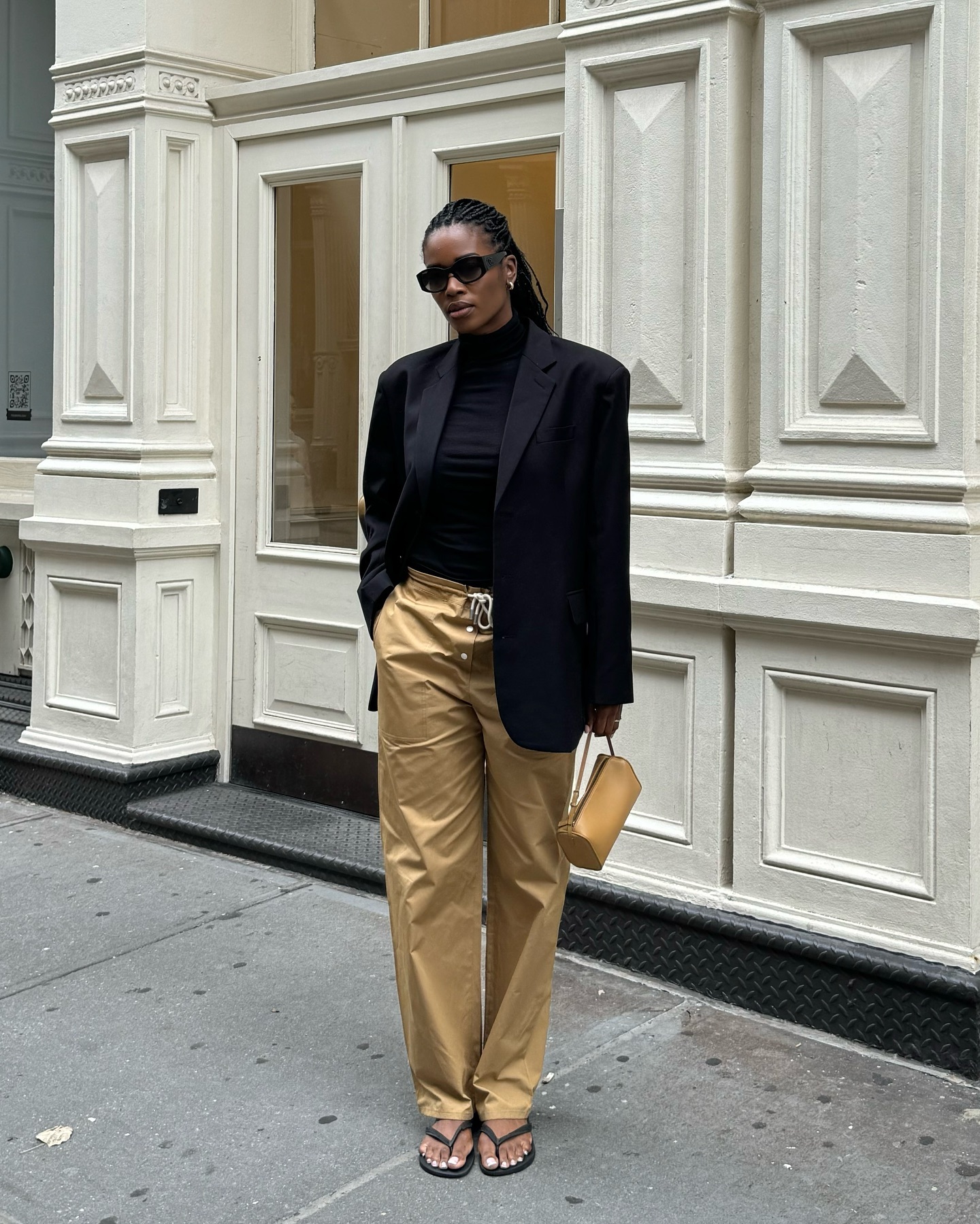 @nlmarilyn wearing a black blazer and tan khaki pants.
