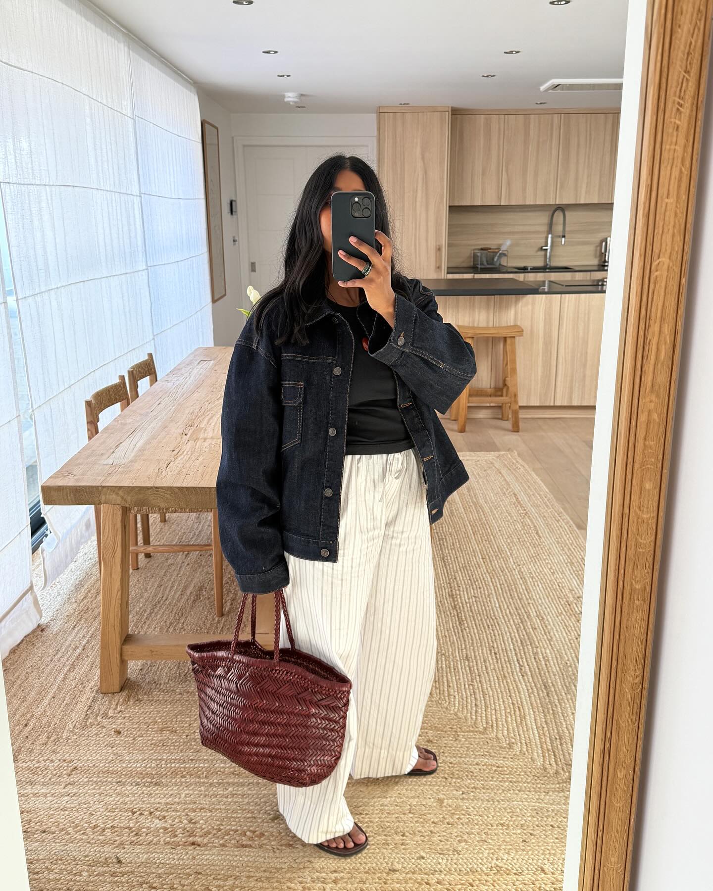 An image of @monikh wearing a woven leather bag.