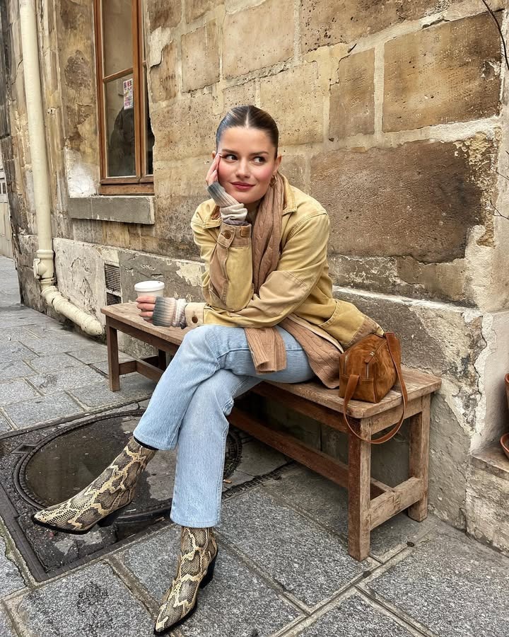 Woman sitting cross-legged with her hair in a middle-parted low updo.