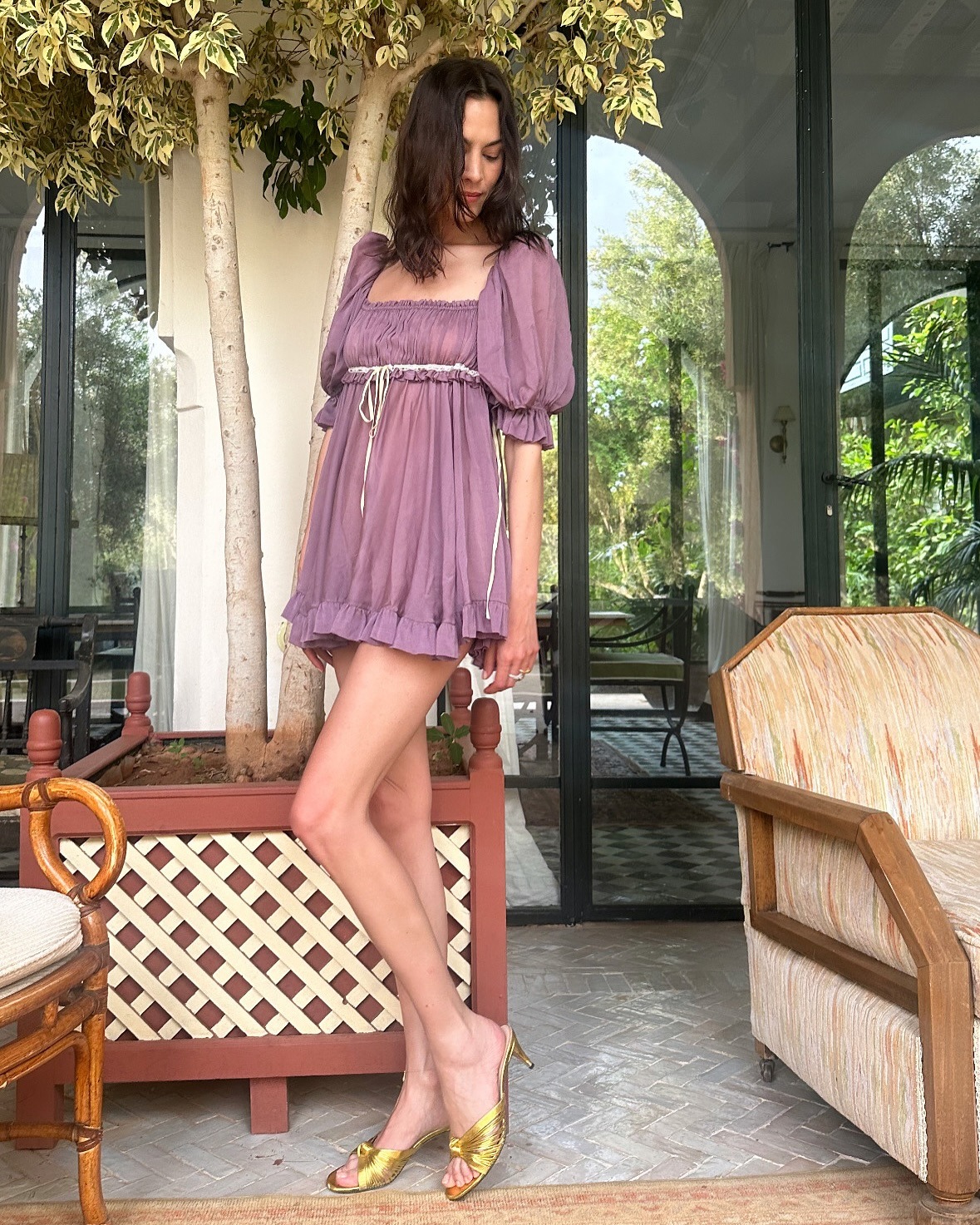 Alexa Chung wears gold sandals.