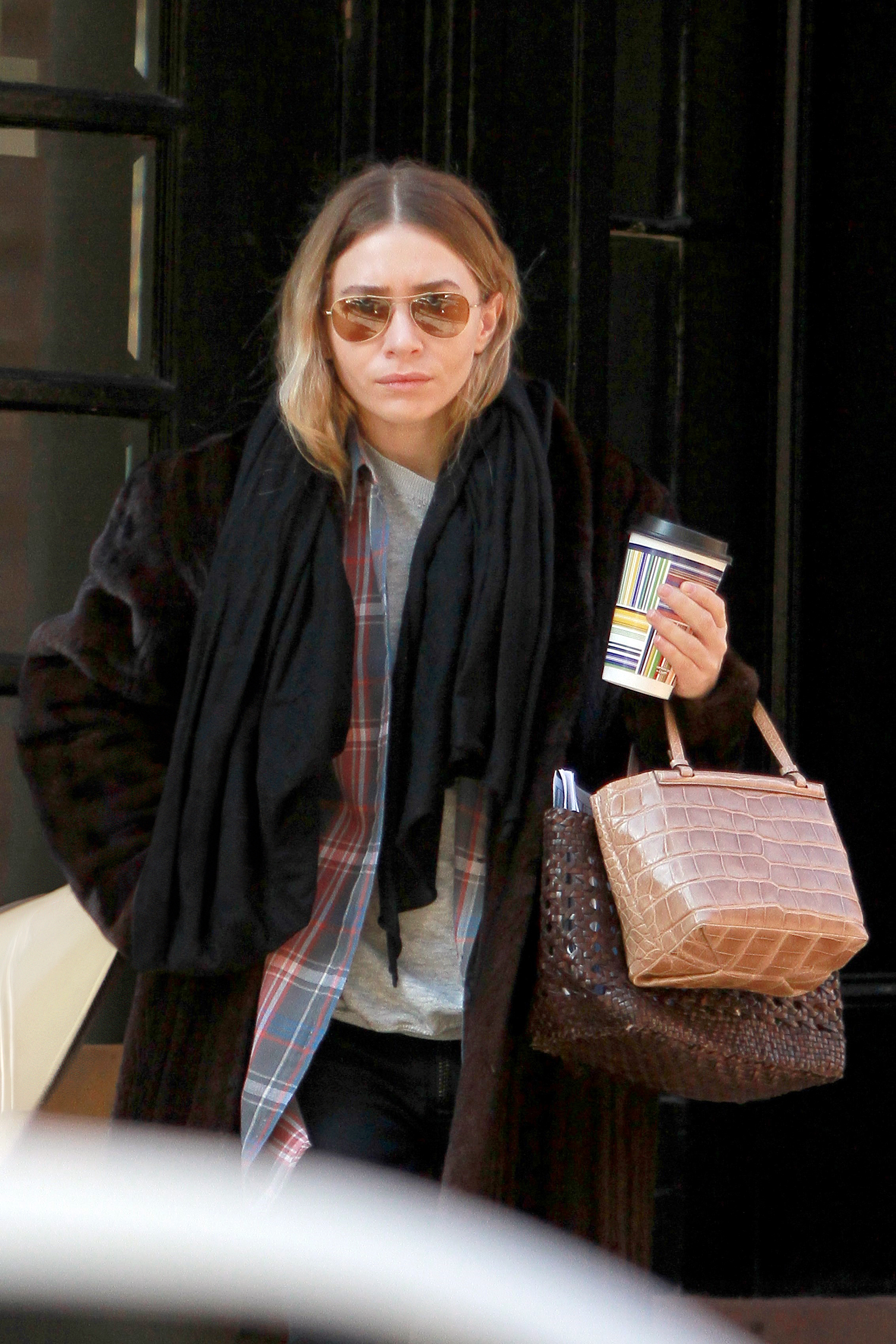 Ashley Olsen spotted in New York City wearing aviator sunglasses, a brown fur coat, black scarf, plaid button-down shirt, gray crewneck T-shirt, a small croc The Row tote bag, and brown Dragon Diffusion woven bag