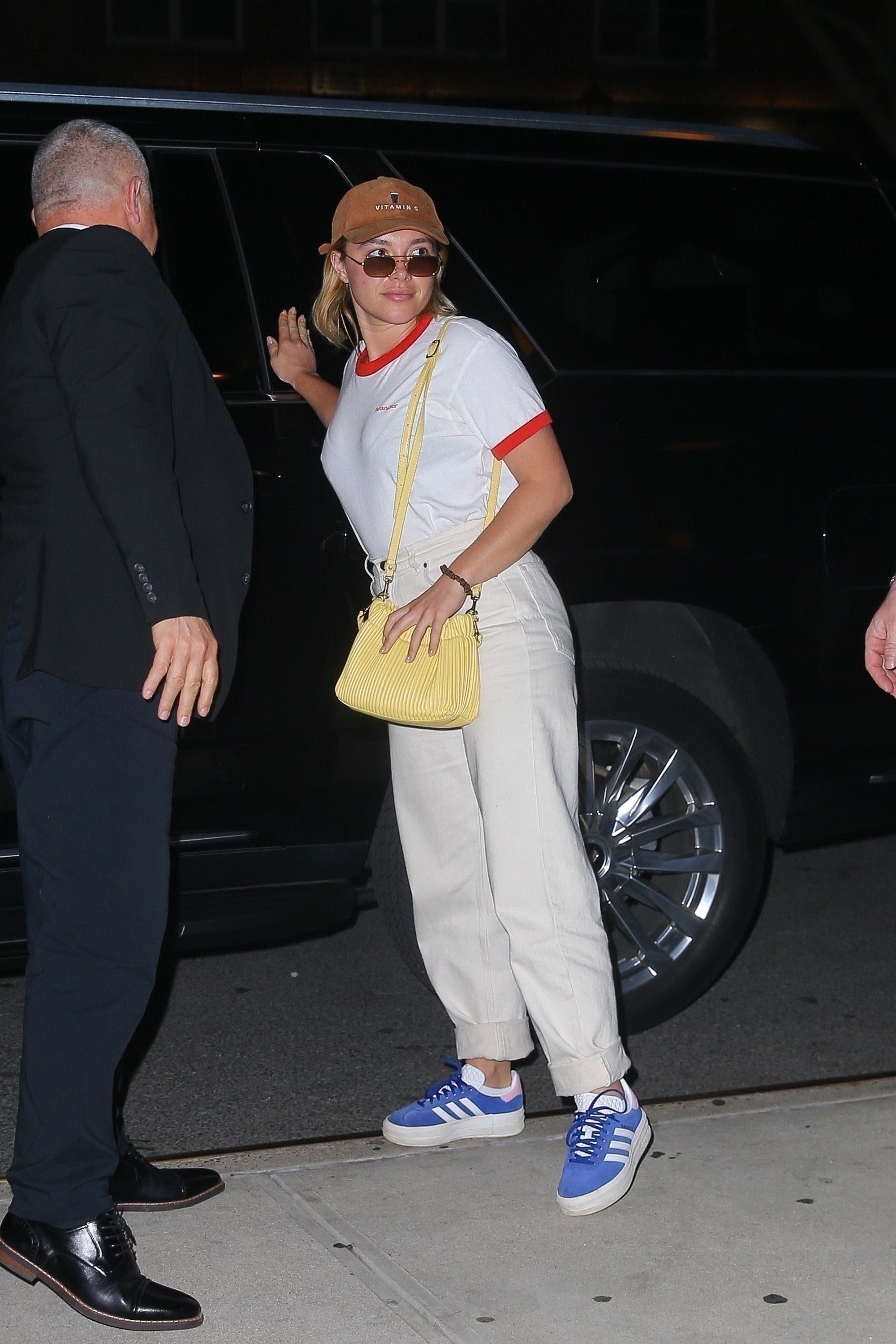 Florence Pugh wears a ringer tee and blue trainers.