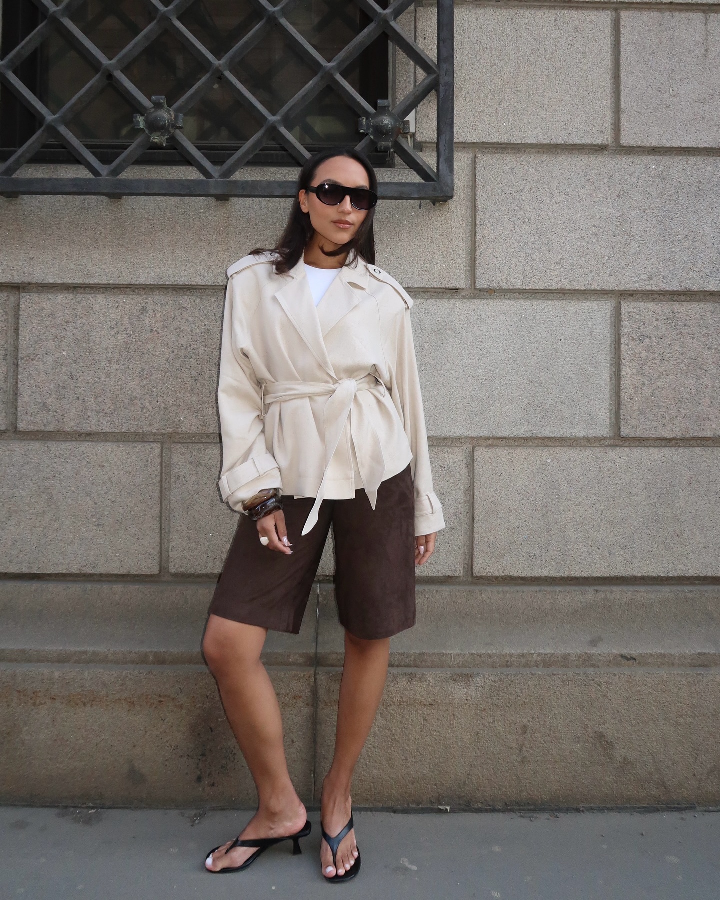 Influencer wears bermuda shorts with heeled flip flops.