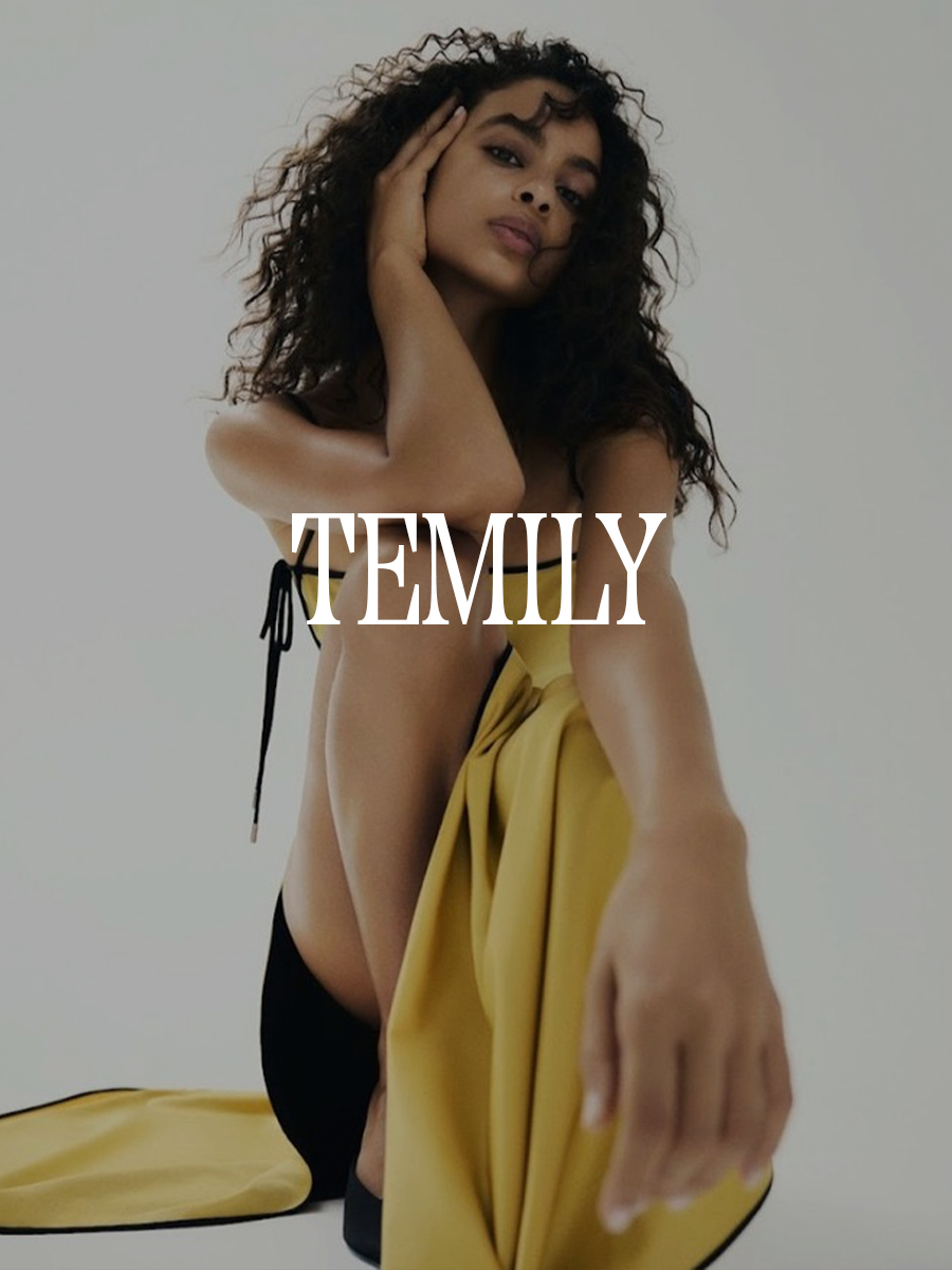 A photo of a model wearing a Temily mustard colored dress. Text says "Temily" in white capital serif letters.
