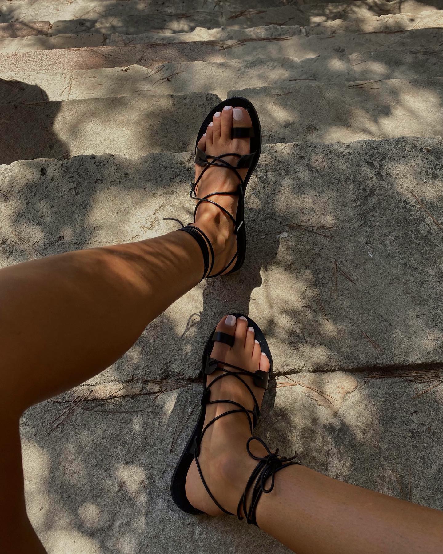 @smythsisters wearing black sandals with a milky pedicure