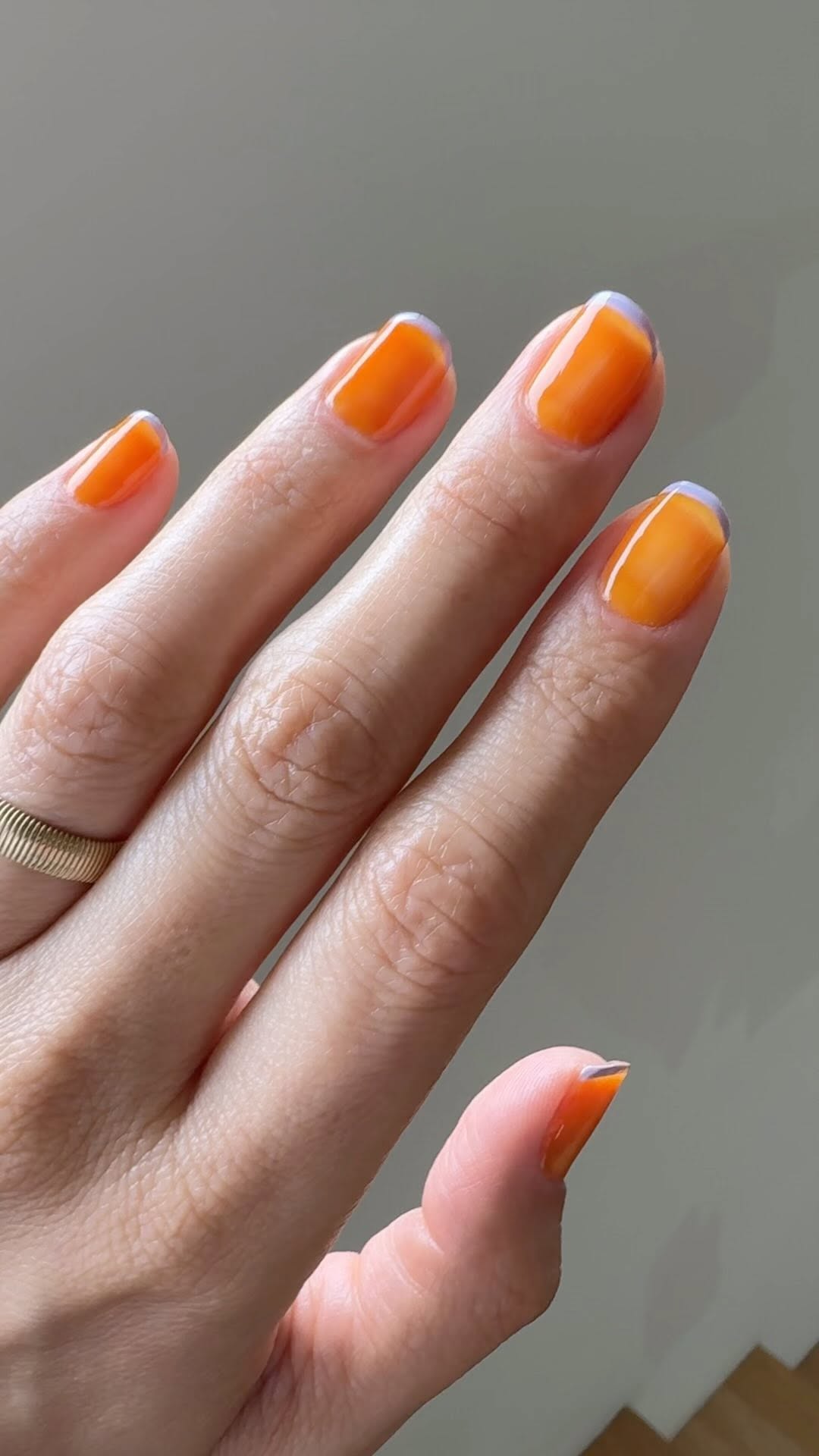 Sheer orange nails with pastel blue tips