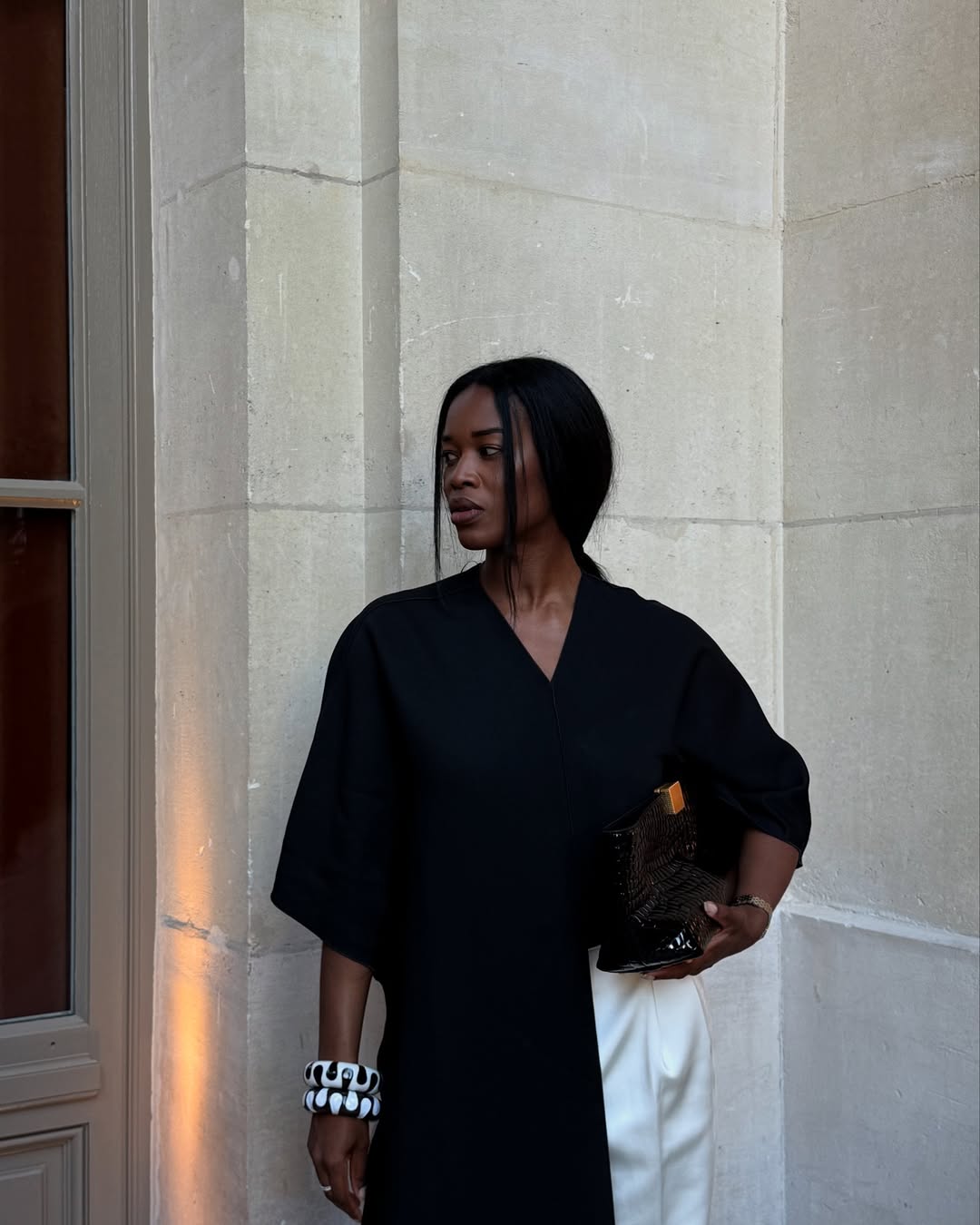 @nlmarilyn wears chunky black and white resin bangles with a black shirt and white trousers