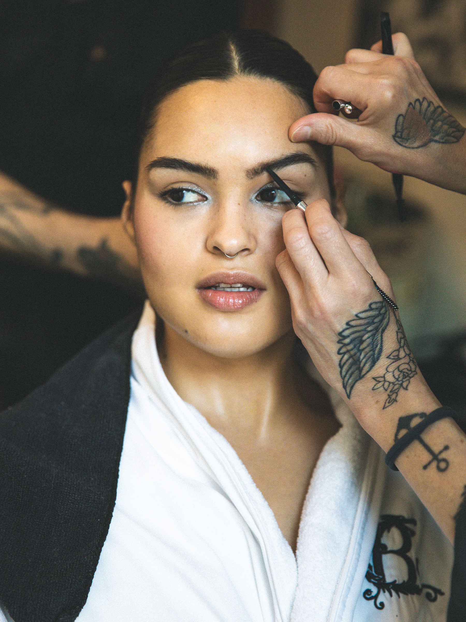 Anna Lambe is sitting in the glam chair getting ready for the Gotham TV Awards. Her makeup artist's hands are in the frame putting finishing touches on her brow.