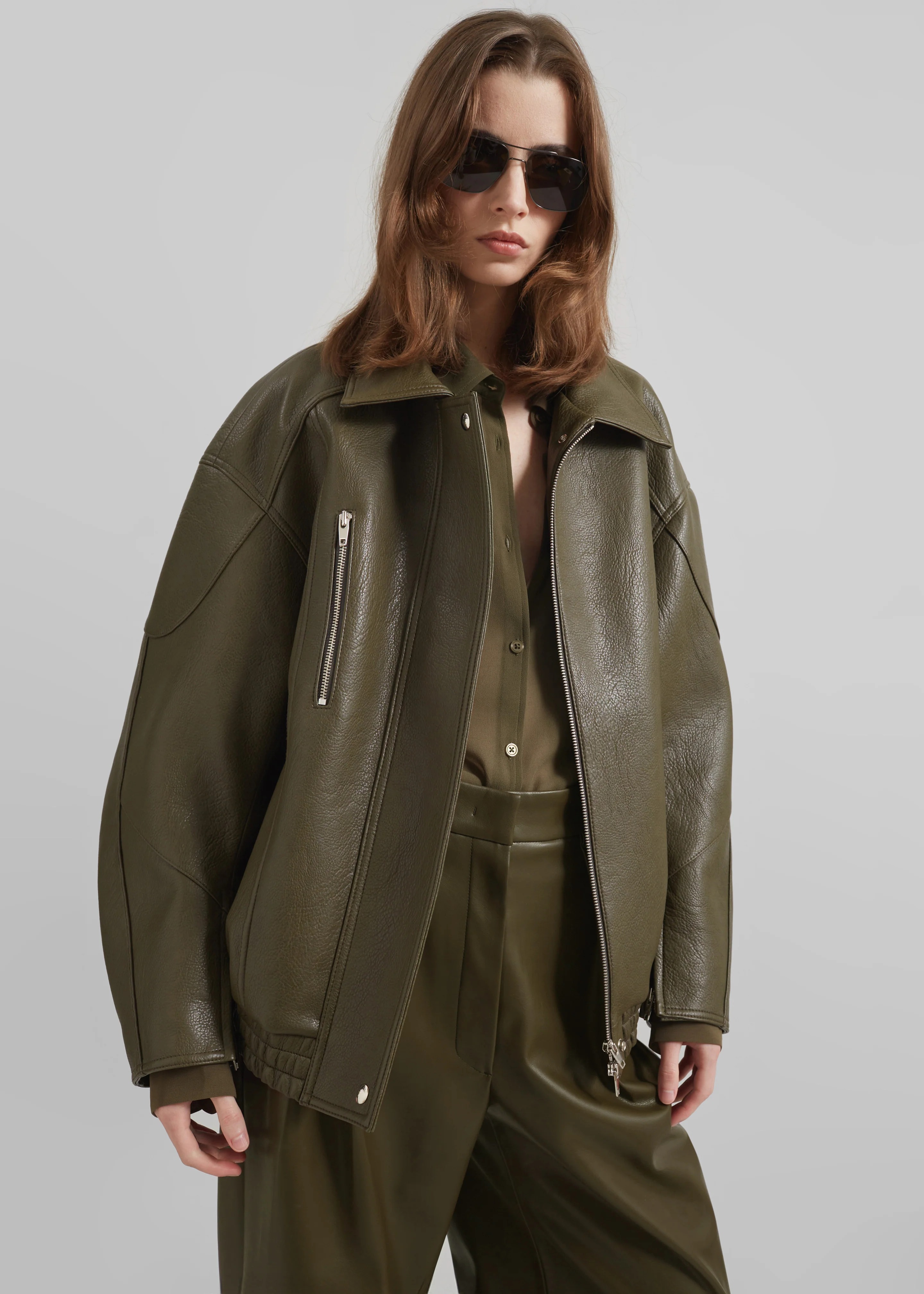 Woman wearing an olive green leather jacket