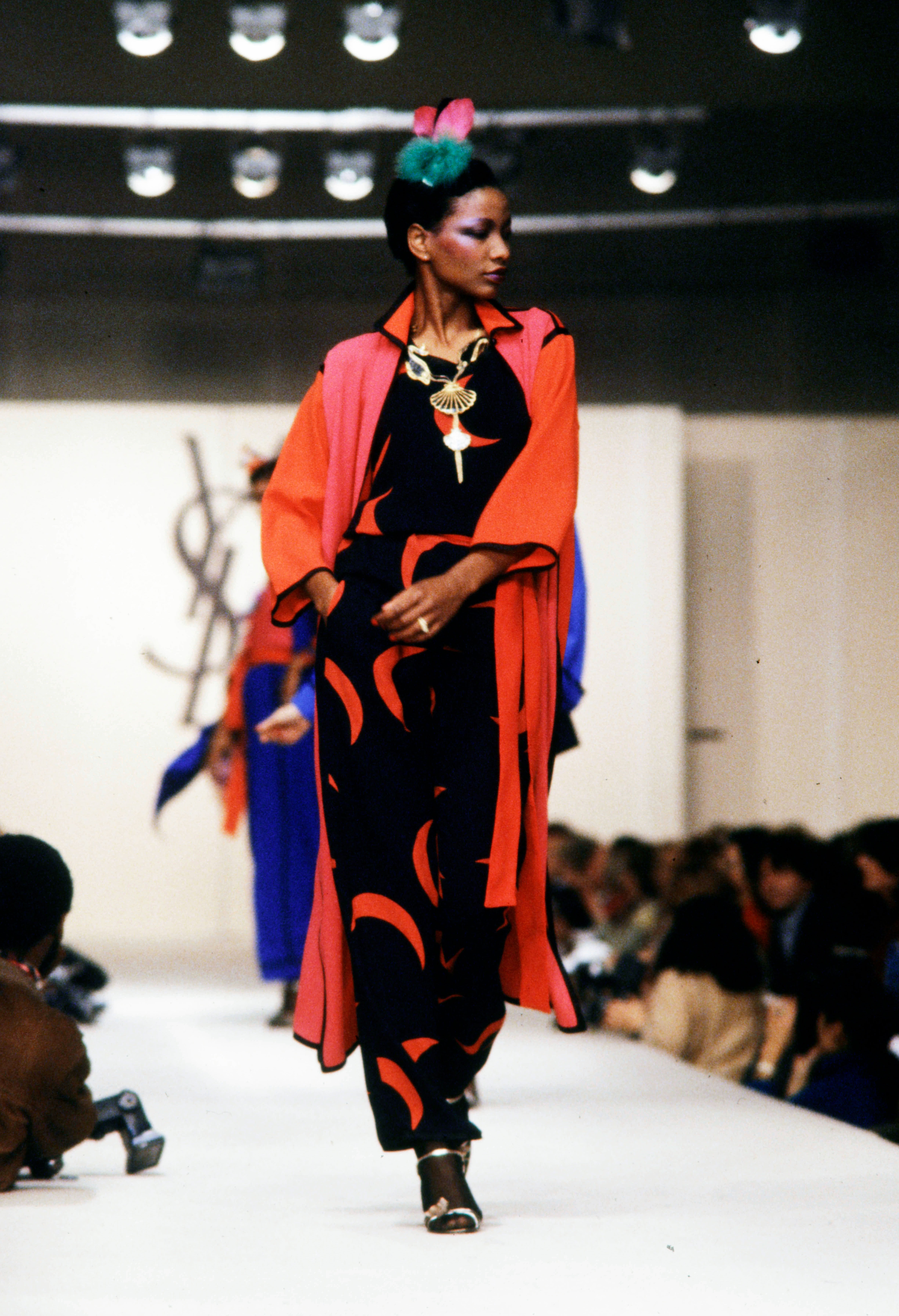 a runway model wears a black and red YSL dress
