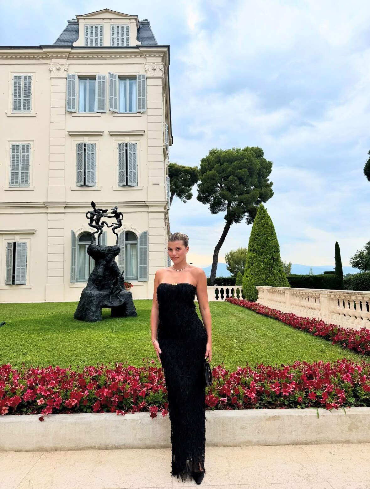 Sofia wears a black strapless dress and black pumps.