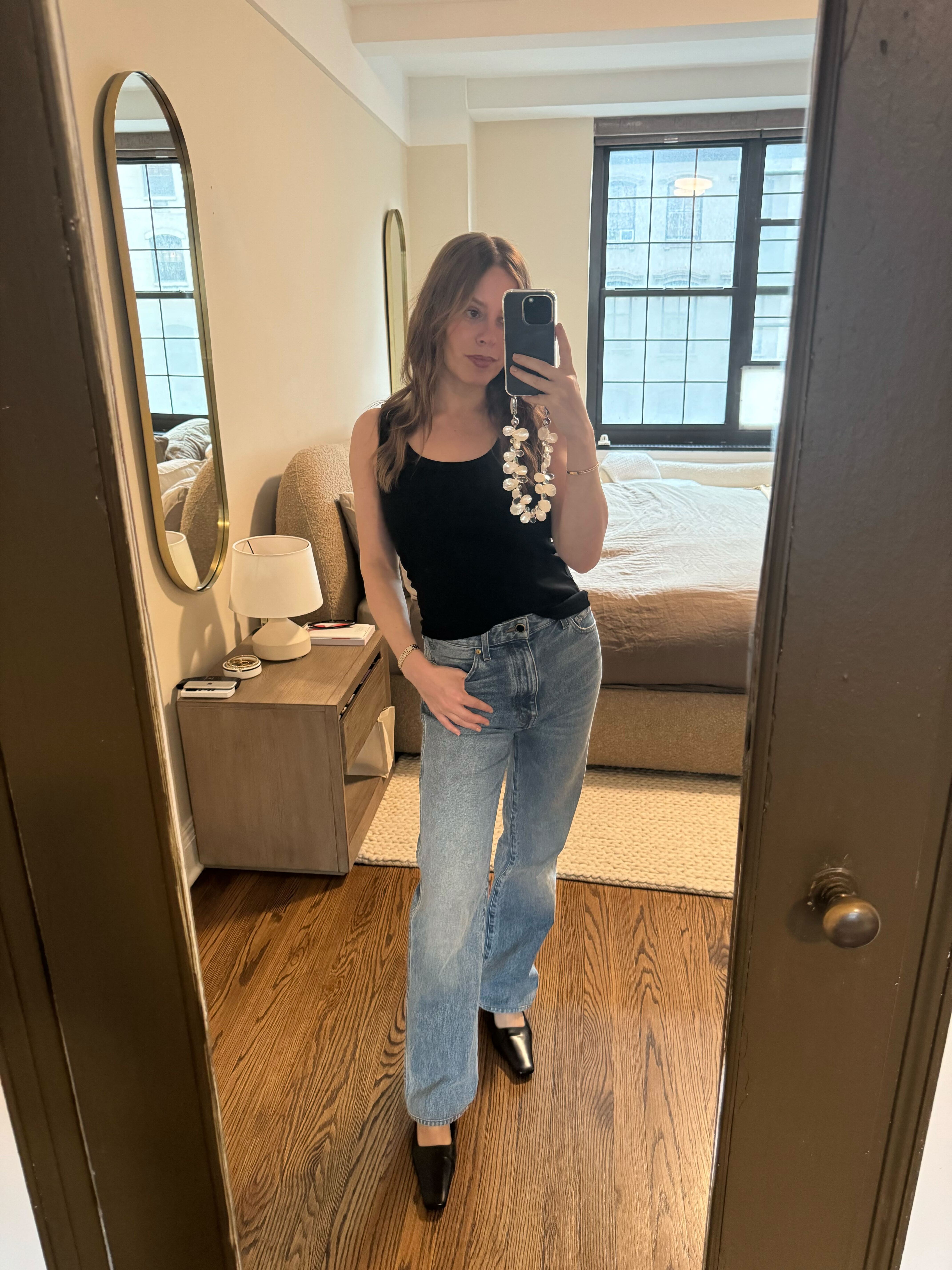 Nikki wears hillie tank top in black, blue jeans, and black pumps.