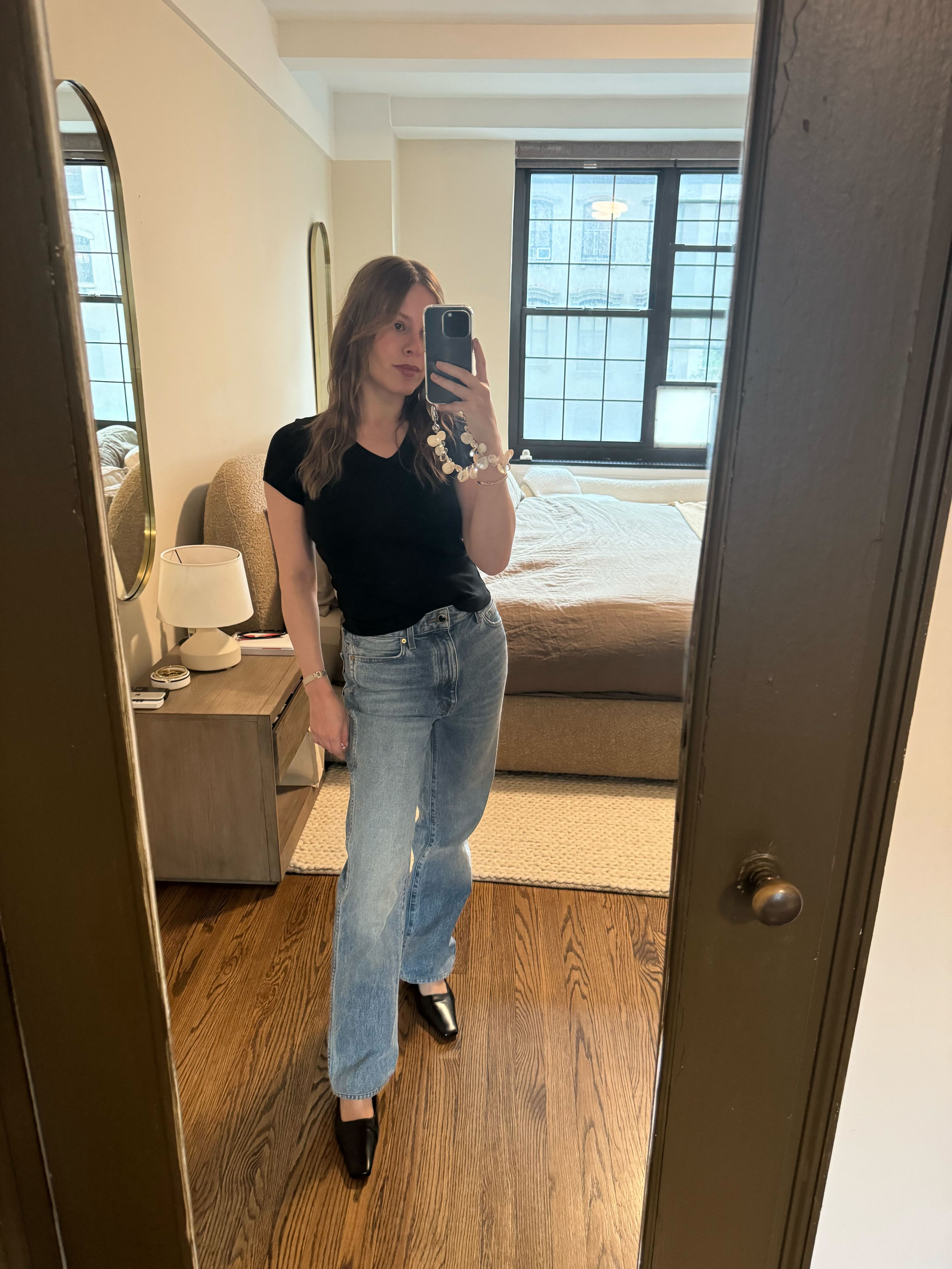 Nikki wears the jill baby tee in black with blue jeans and black pumps.