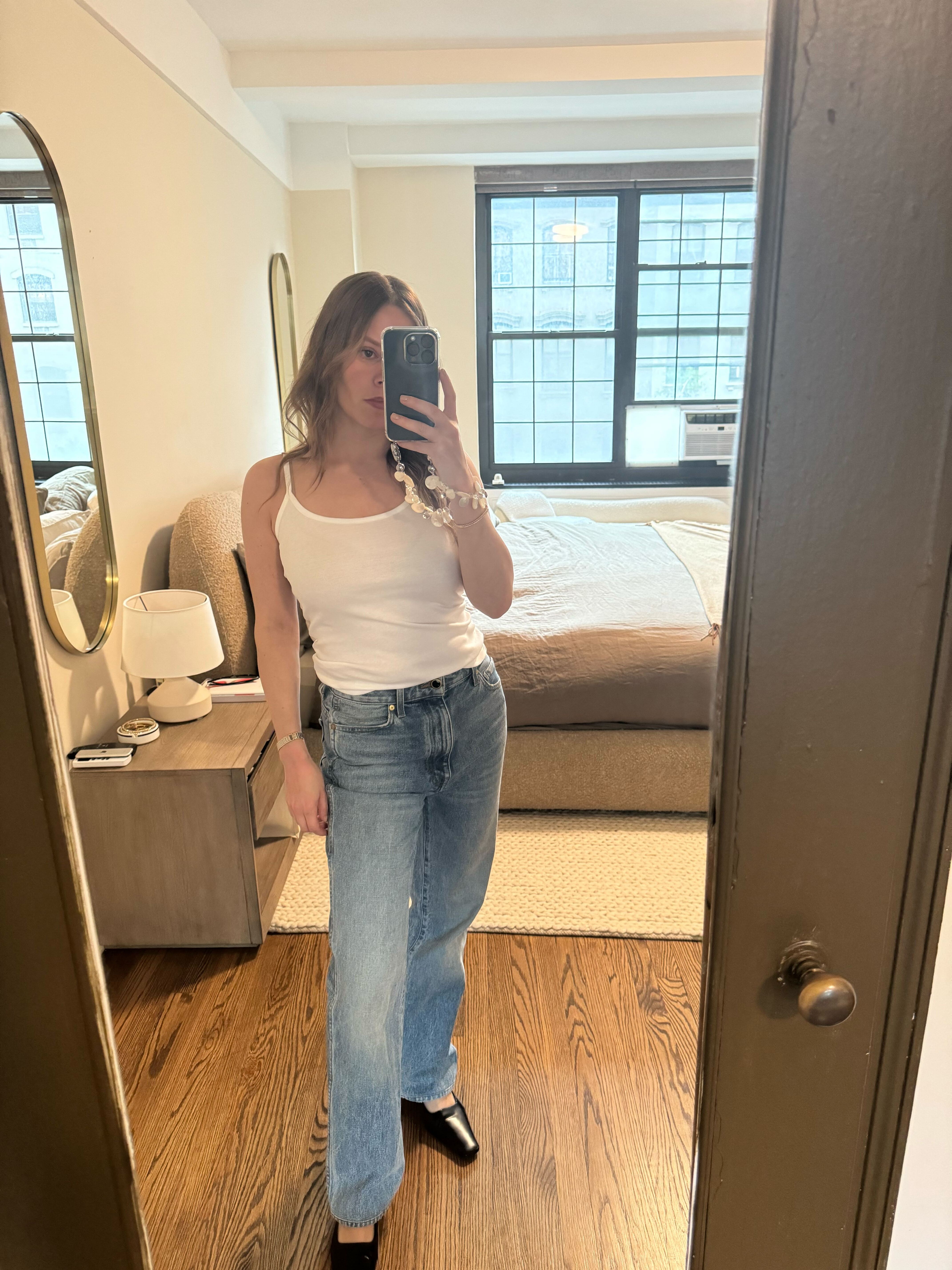 Nikki wears the white bibi cami top, blue jeans, and black pumps.