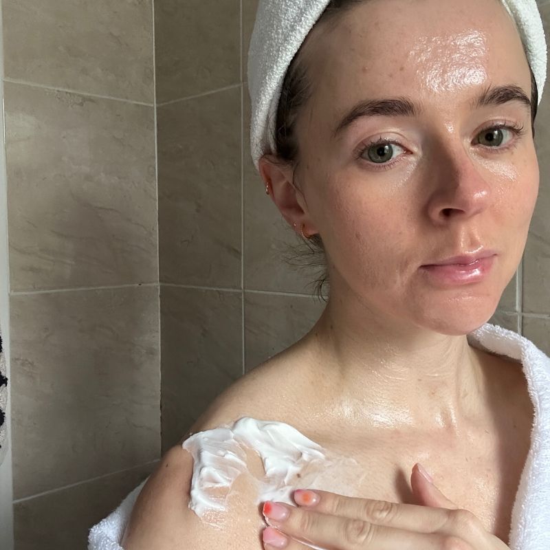 Grace applying body cream to her shoulders