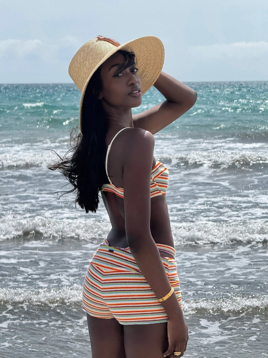 A woman standing wearing a Triangl boy short bikini set.