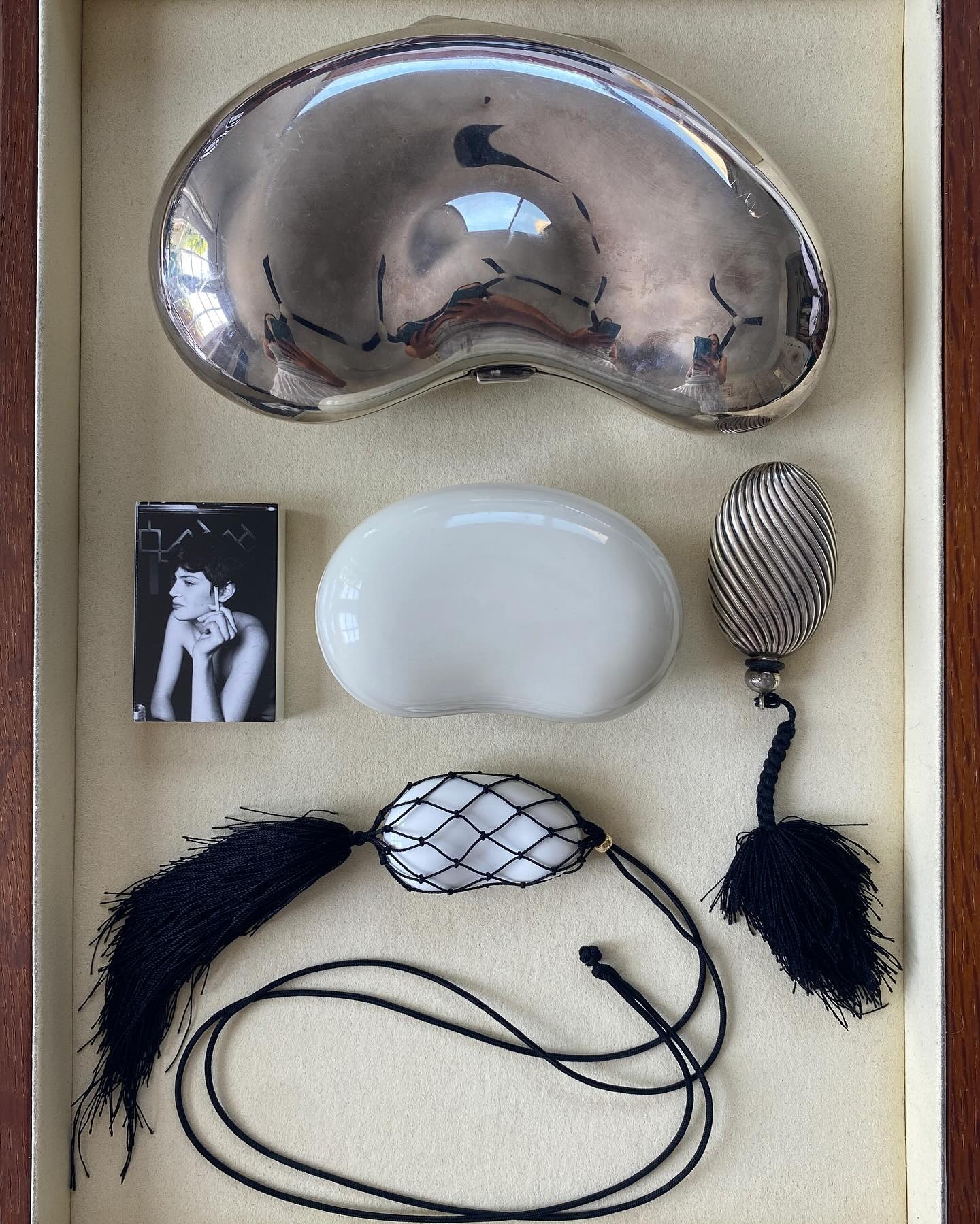 A tray of objects including a tassel necklace and tassel adorned object.