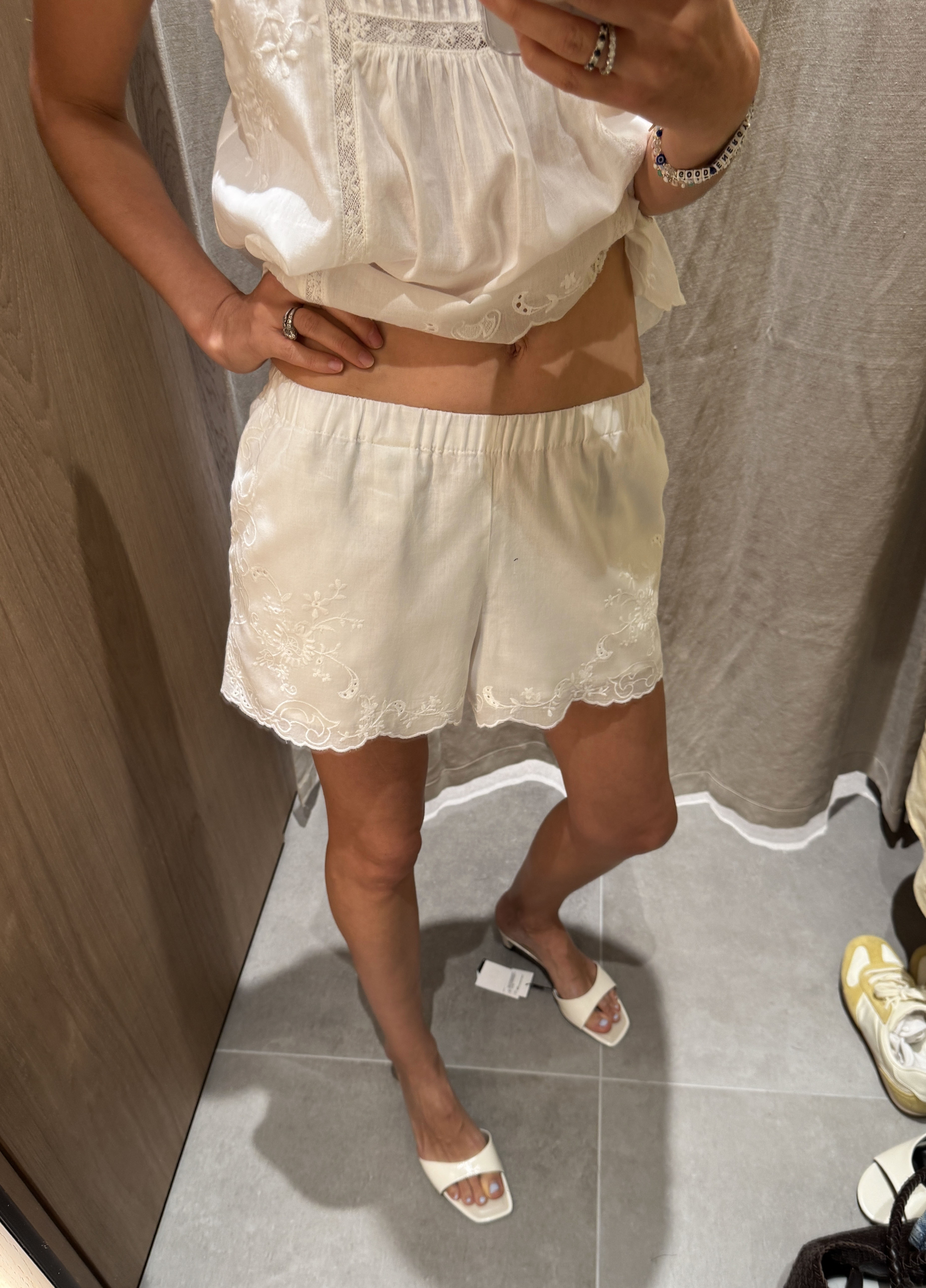 Woman in white embroidered shorts