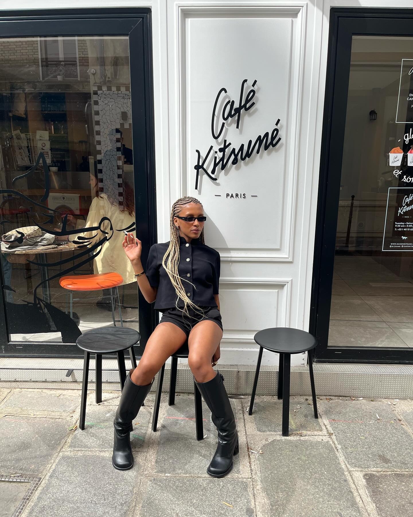 A woman sat outside a cafe with linen blonde hair