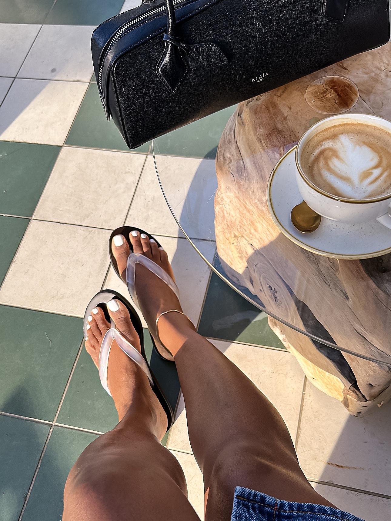 Woman wears jelly flip-flips, denim skirt.