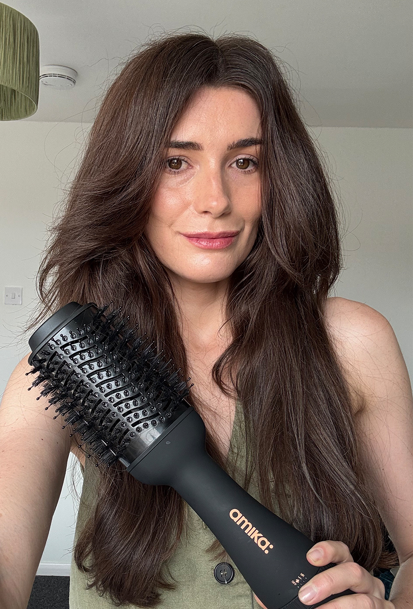Eleanor holding Amika hot brush blow dryer in hand