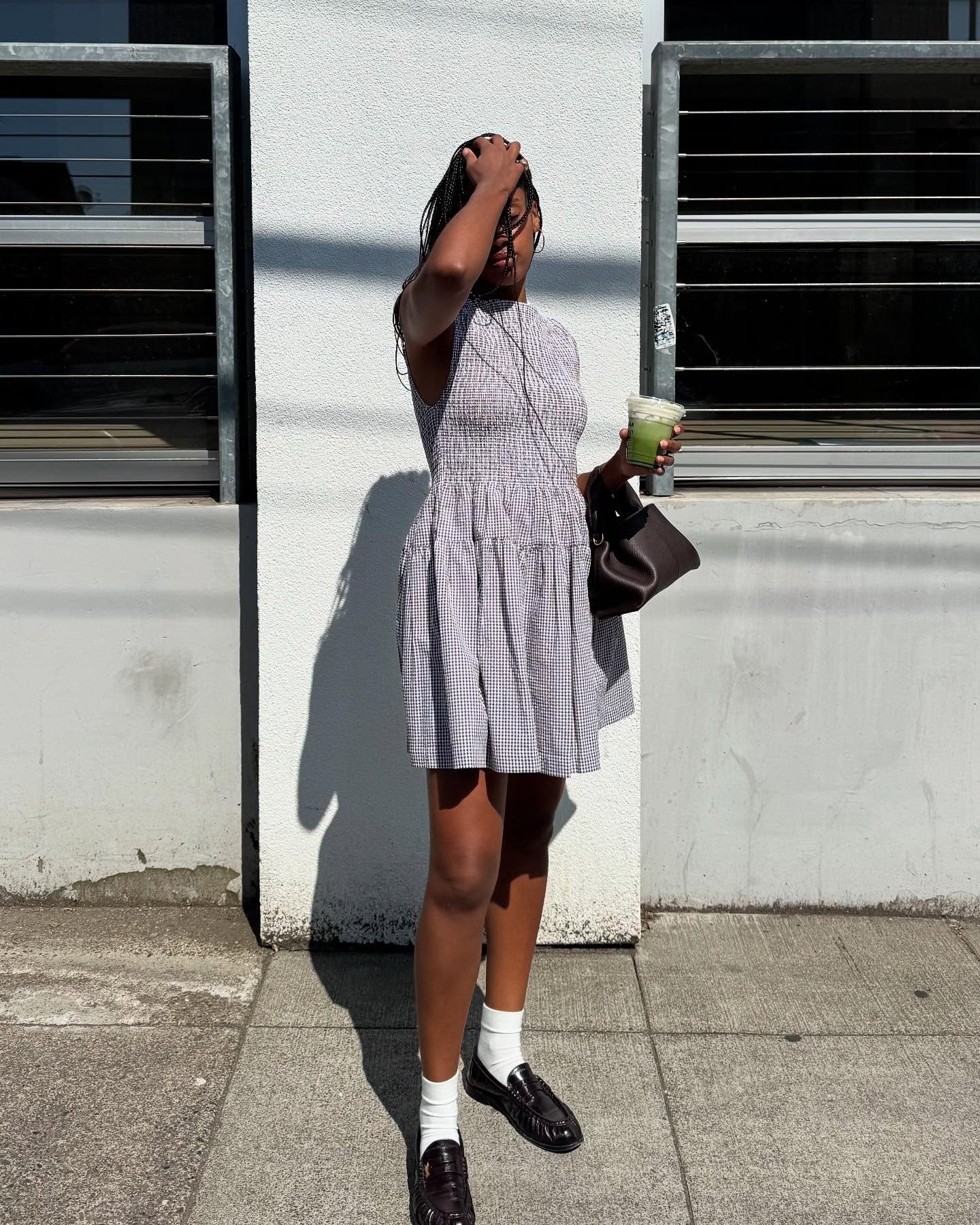 French influencer wearing a dress, white socks, and brown loafers