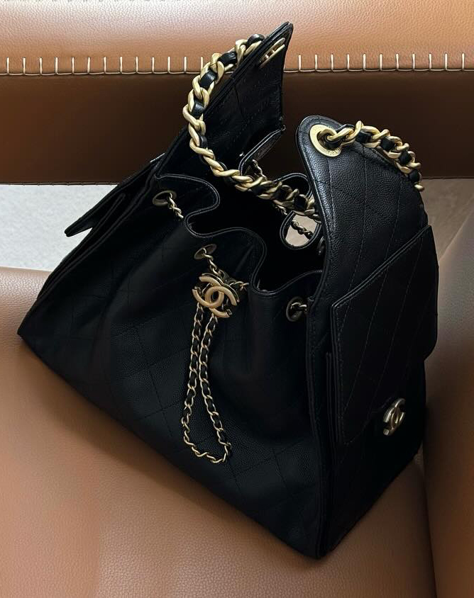 @rikkekrefting shares her black Chanel bag, which she photographed on a tan leather chair