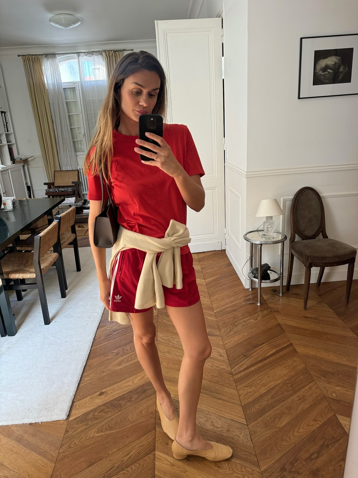 A woman wearing a red t-shirt and red athletic shorts.