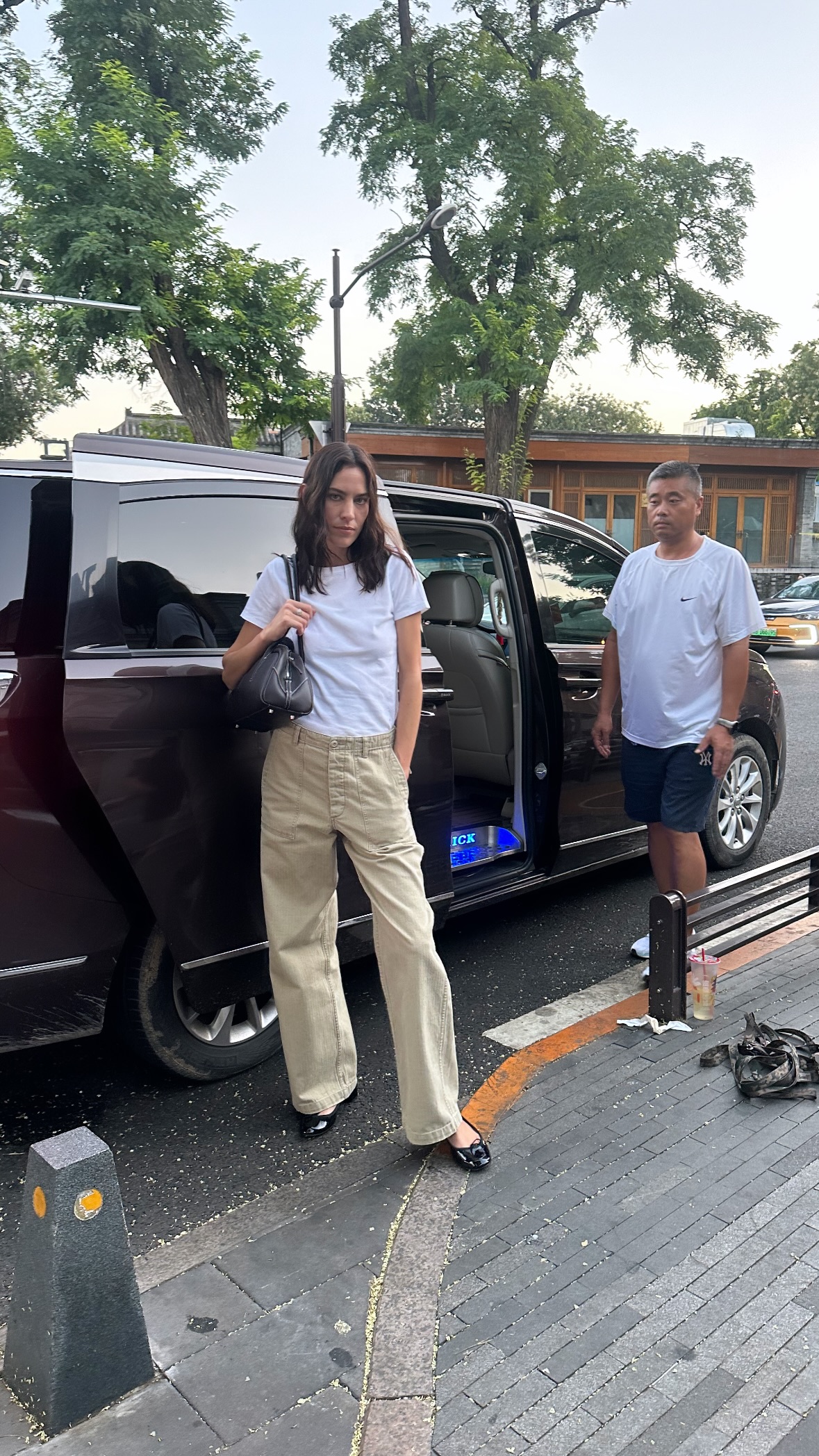 Influencer @alexachung wears a white t-shirt with beige jeans, black ballet flats with a black handbag.
