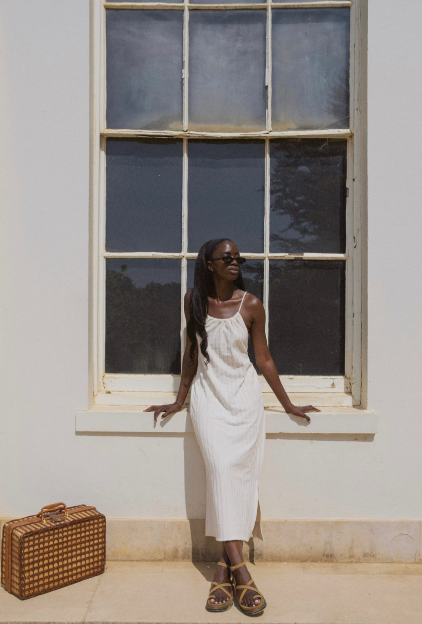 An image of @_livmadeline wearing toe-ring sandals with a white maxi dress.