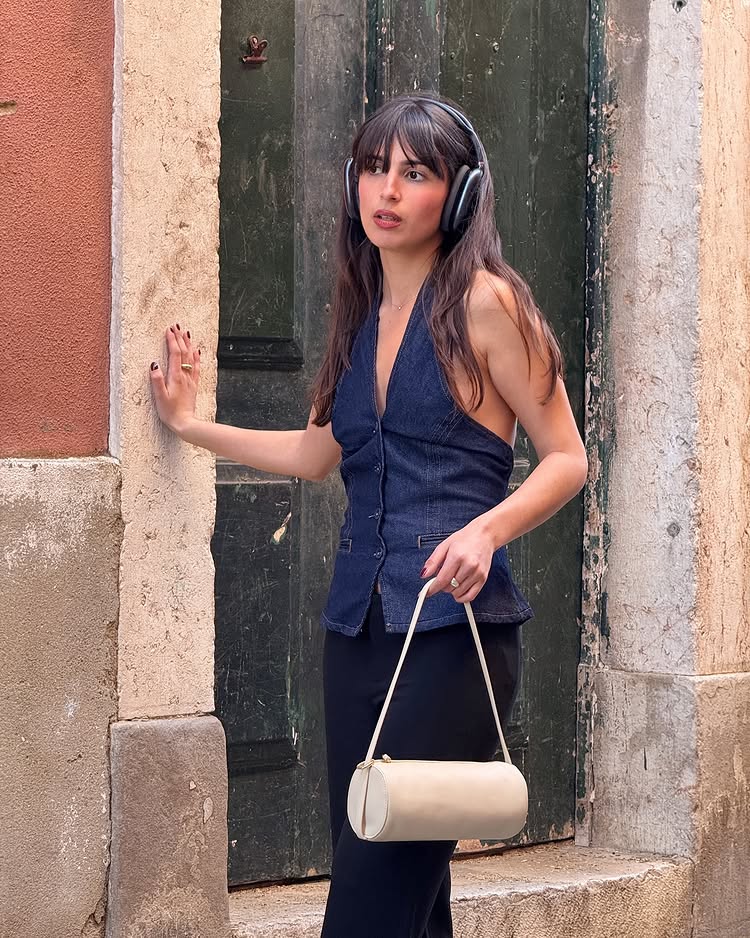 @tamaramory wears a denim halter top with dark navy trousers and a cream bag
