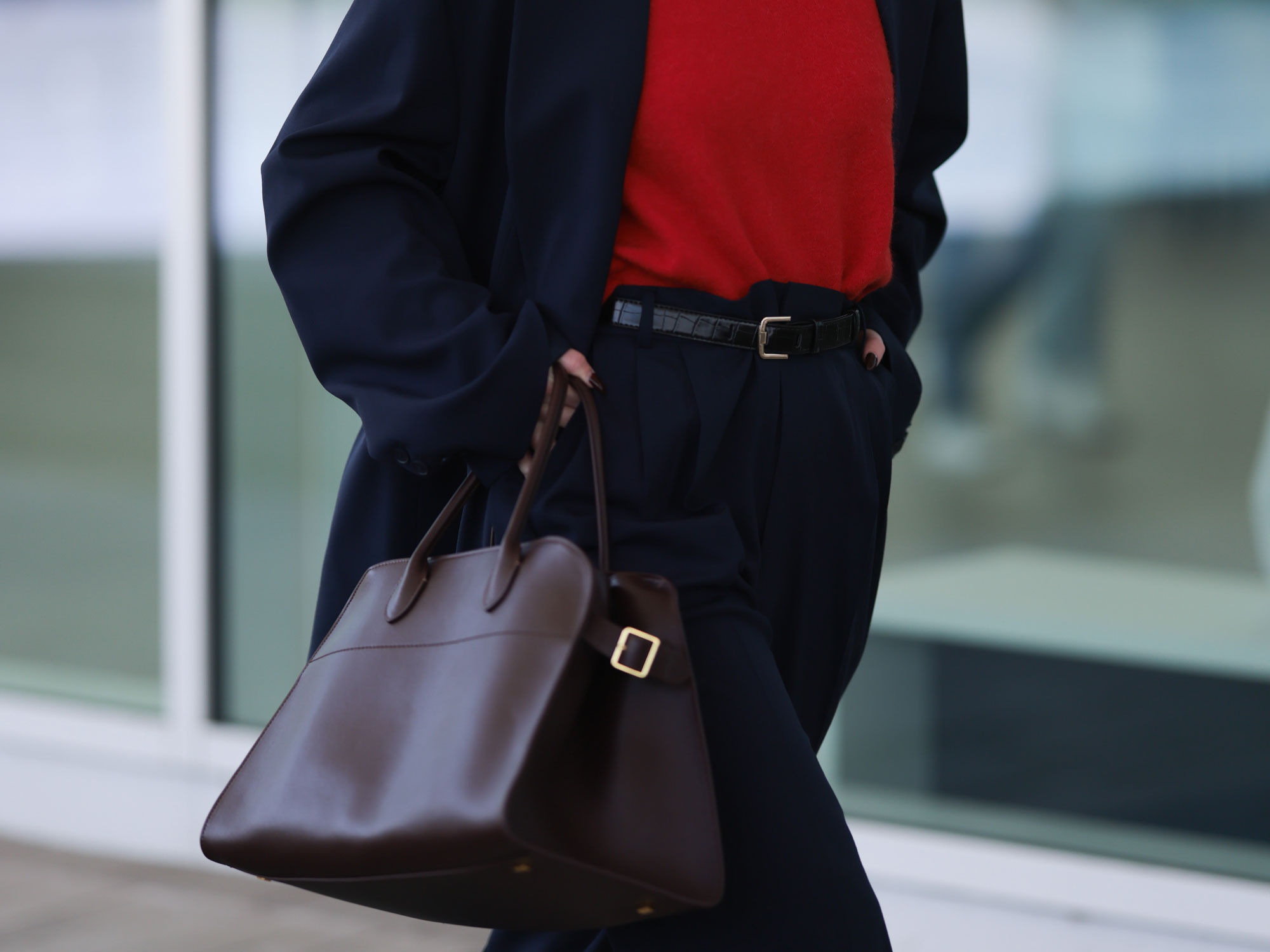 a woman wears The Row's Margaux Bag