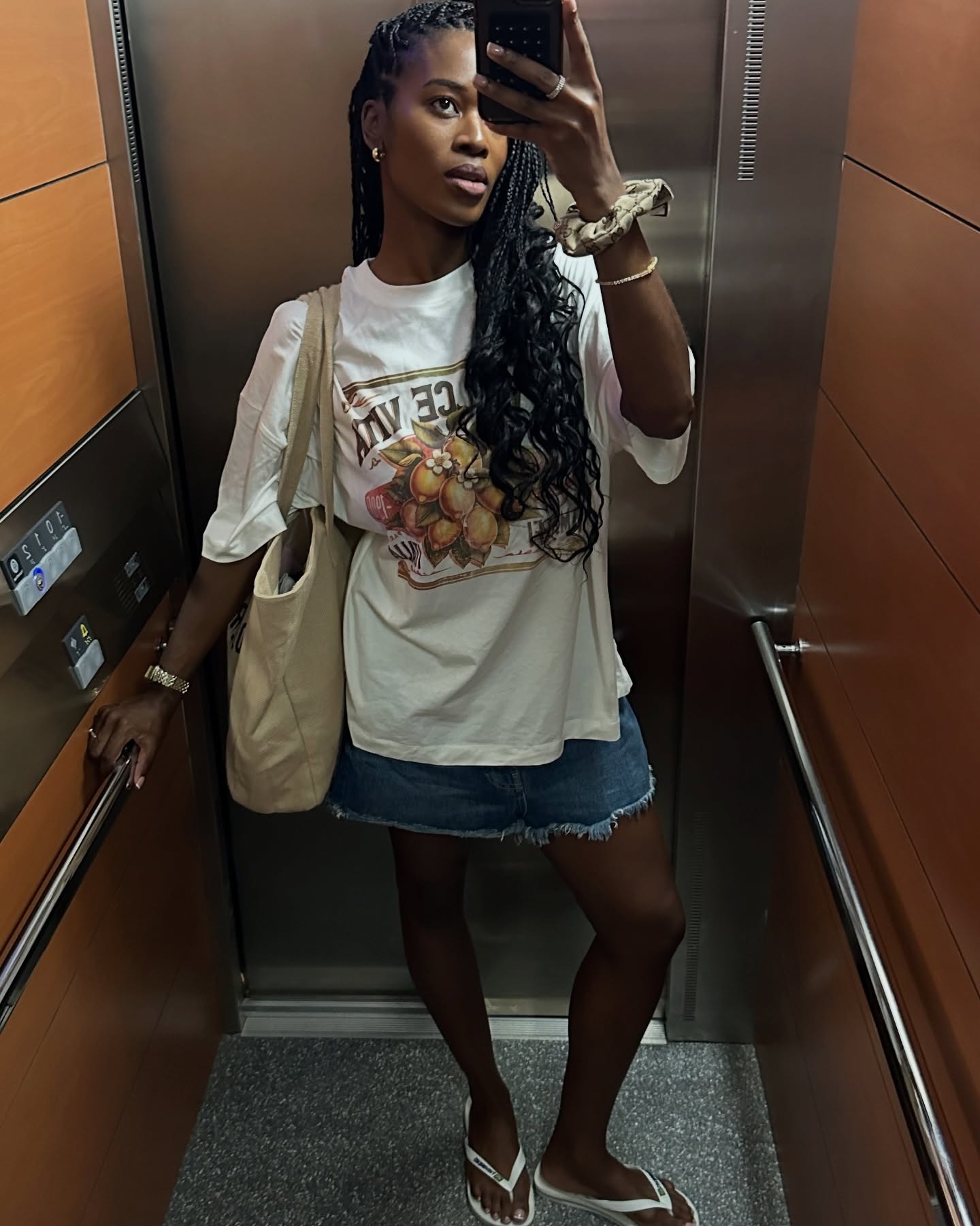 Influencer Marilyn wears white Havaianas, a denim mini skirt, and a graphic tee.