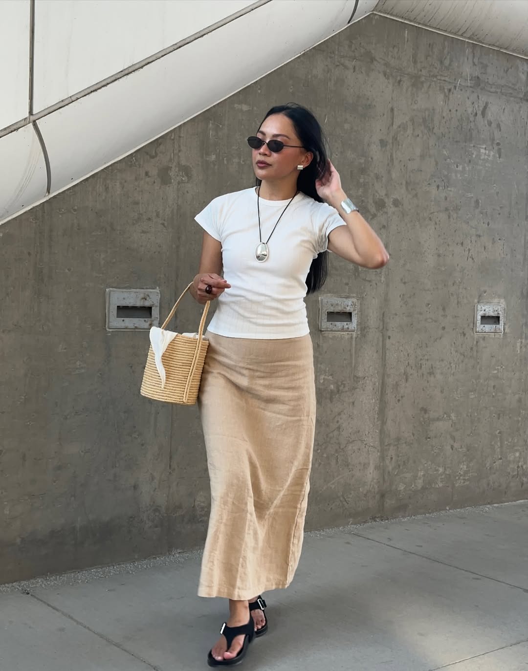 Influencer Dawn Tan wears a beige linen skirt with a classic white tee and a pair of suede slingback sandals.