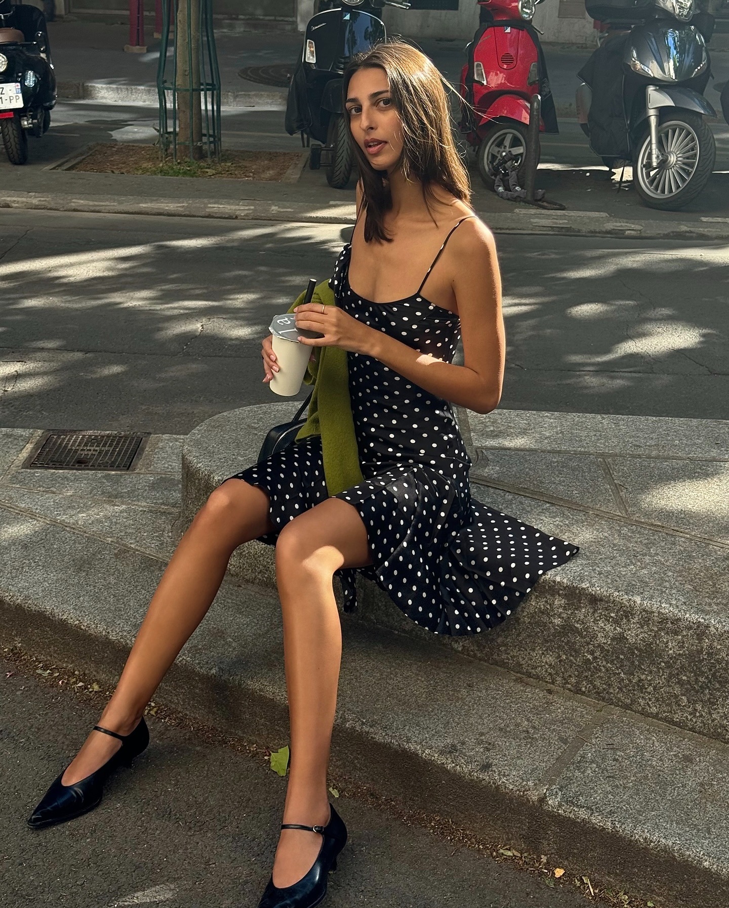 Influencer @salome.mory wears a polka dot dress with black pointed toe ballet flats.