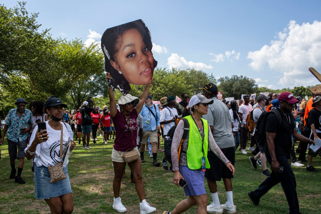 A civil rights supporter holds up a photo of Breonna Taylor...