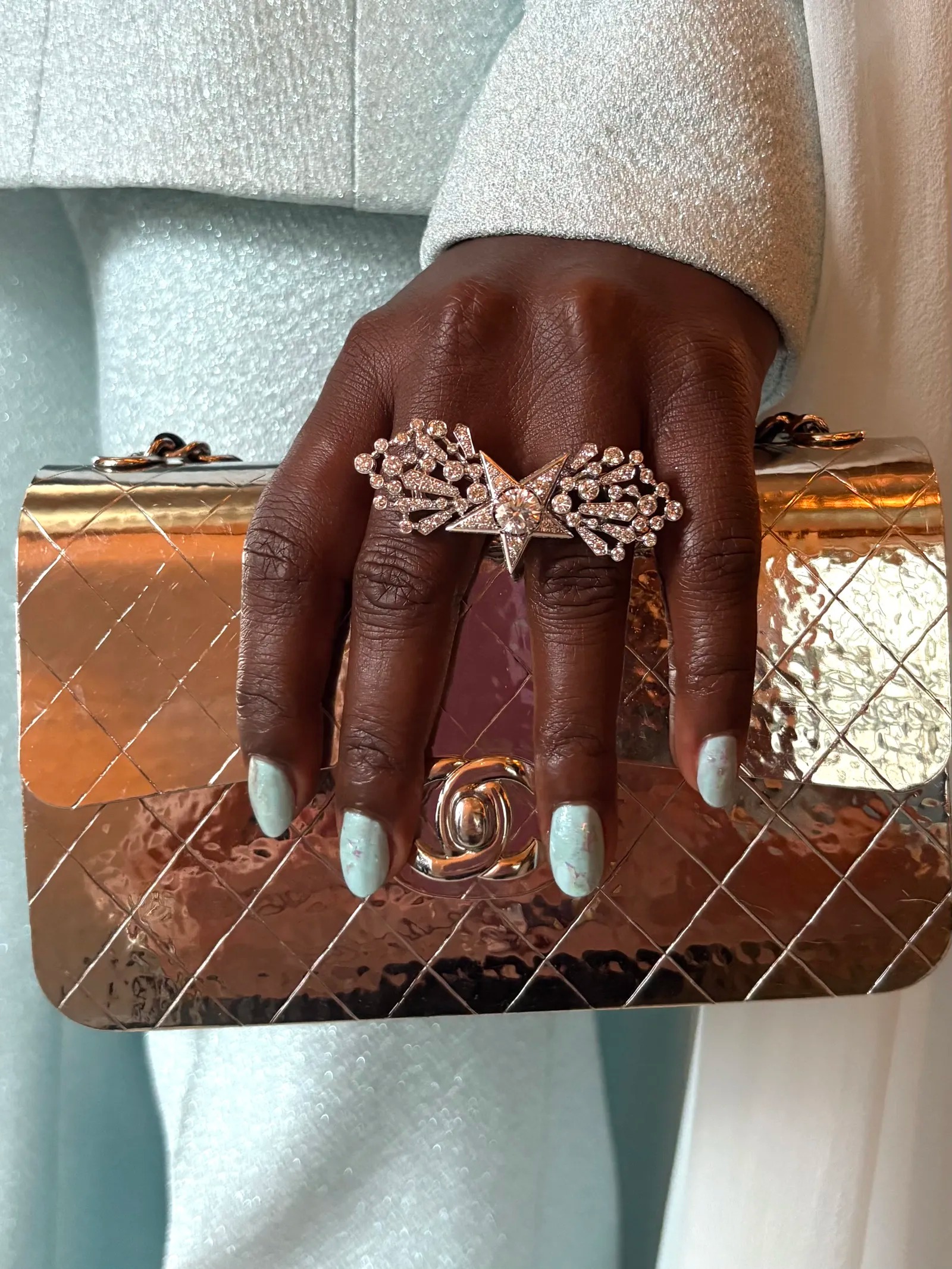 An image of Lupita Nyong’o with watery blue nail polish.