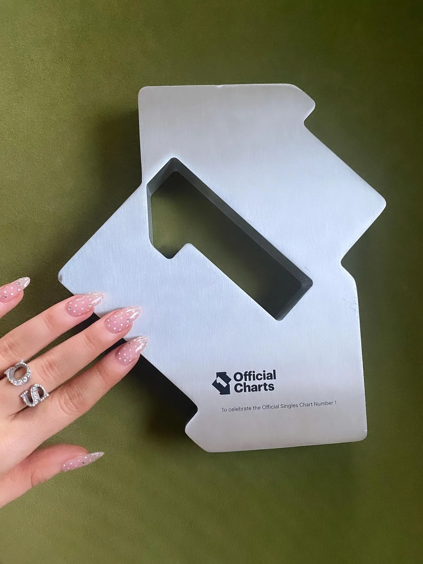 An image from Sabrina Carpenter's Instagram of her pink and white polka dot manicure.