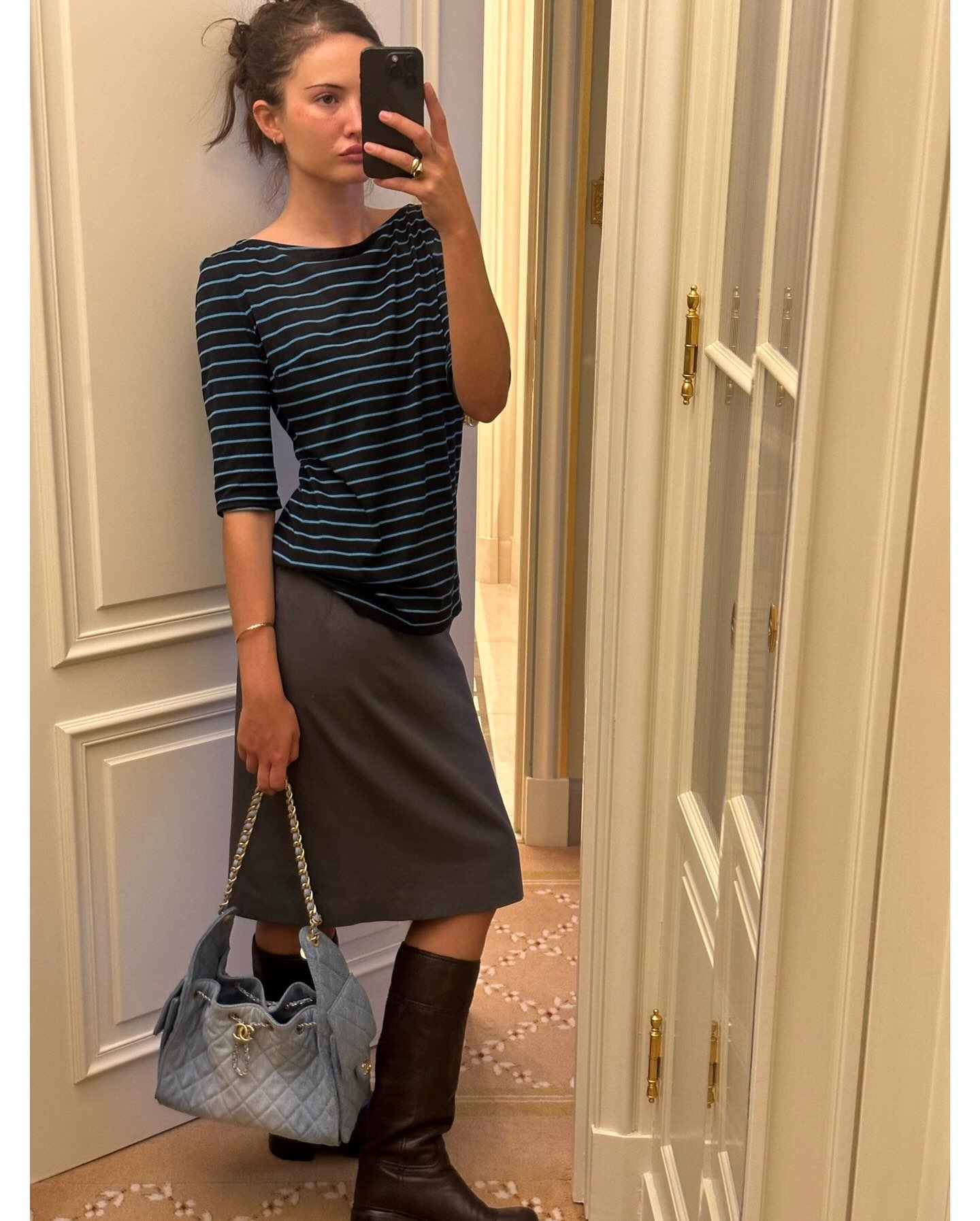 Influencer @rubylyn_ wears the Chanel 25 Handbag in blue denim with a linen pencil skirt and striped t-shirt.