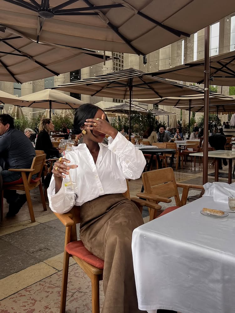 @aidabadji_ wears a white shirt and brown skirt