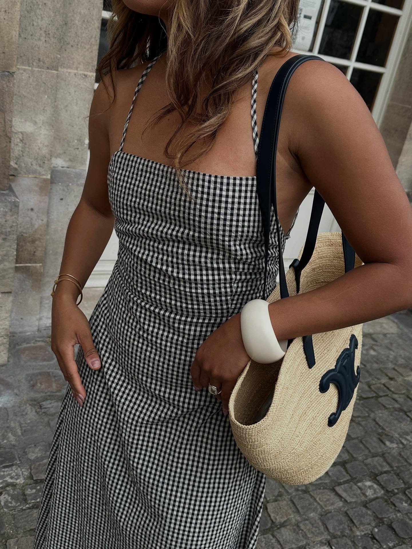 Woman holding a designer beach bag from Celine.