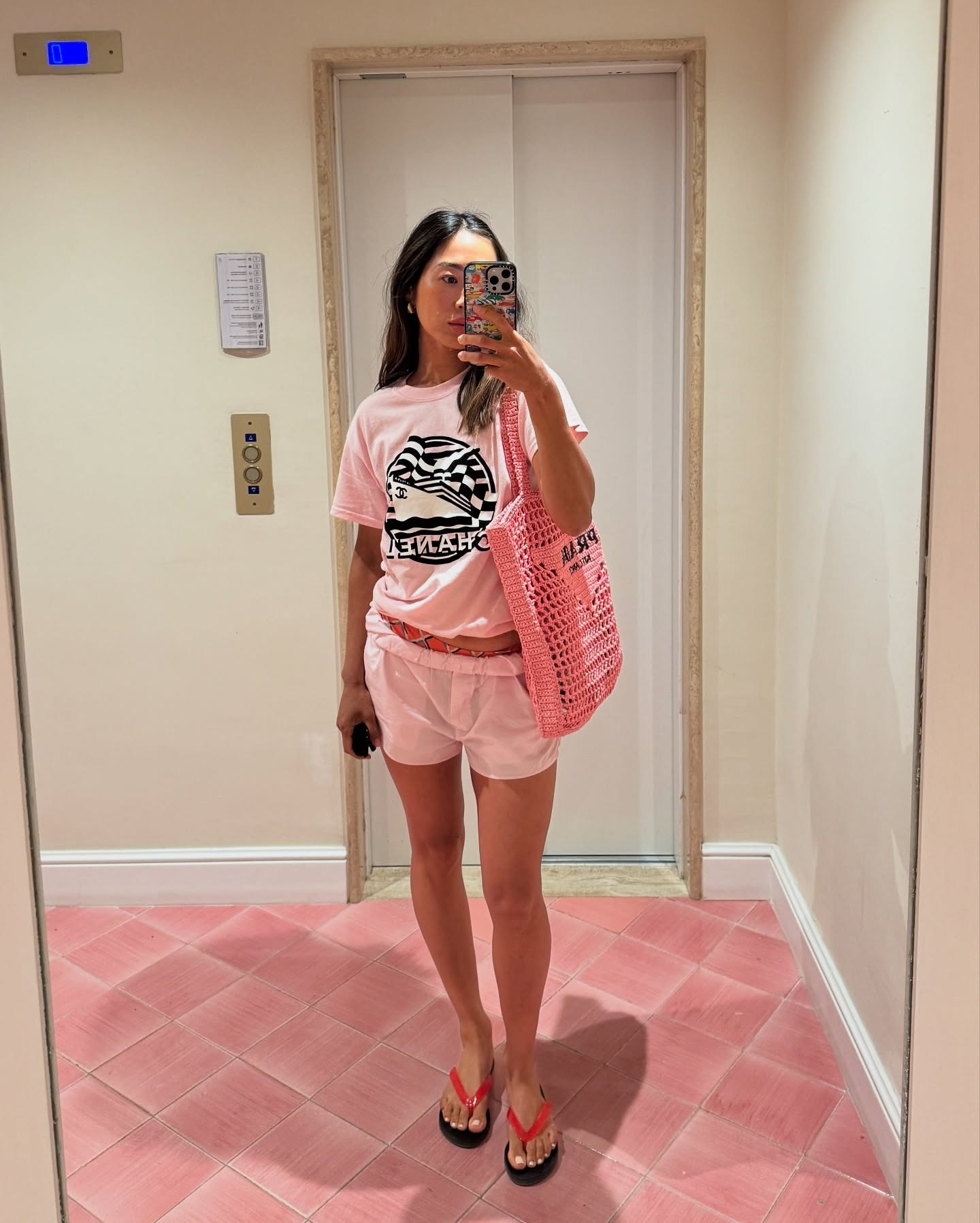 Woman holding a designer beach bag from Prada.