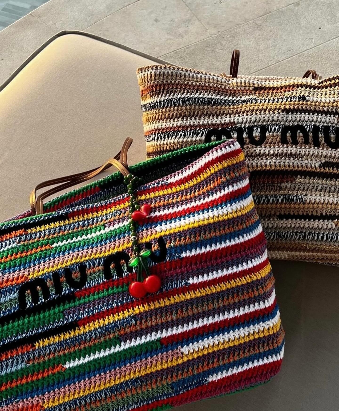 Designer beach bags from Miu Miu sitting on a chair.