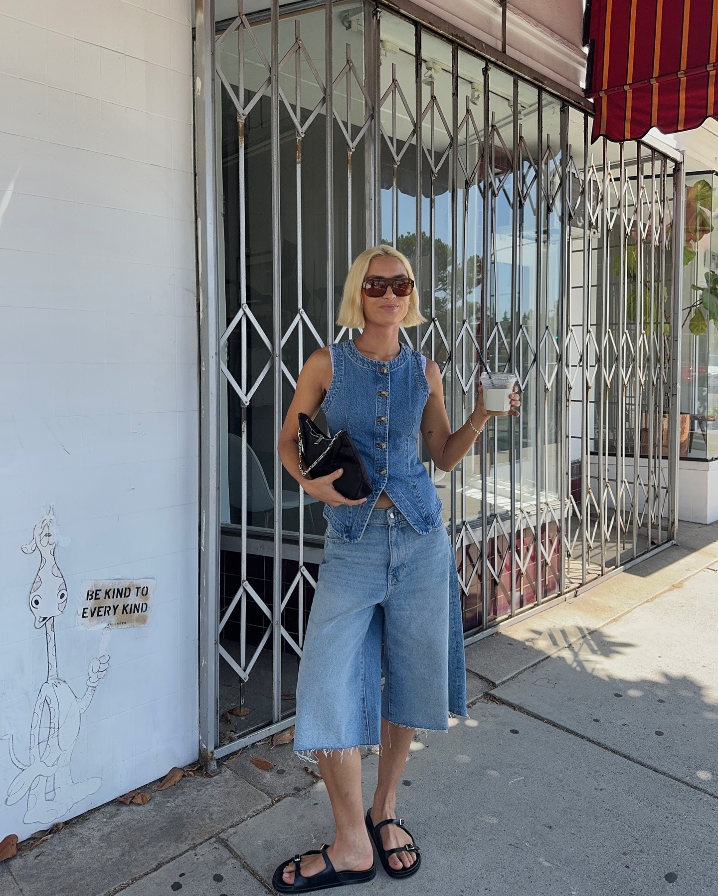 A woman wearing a denim vest and denim shorts
