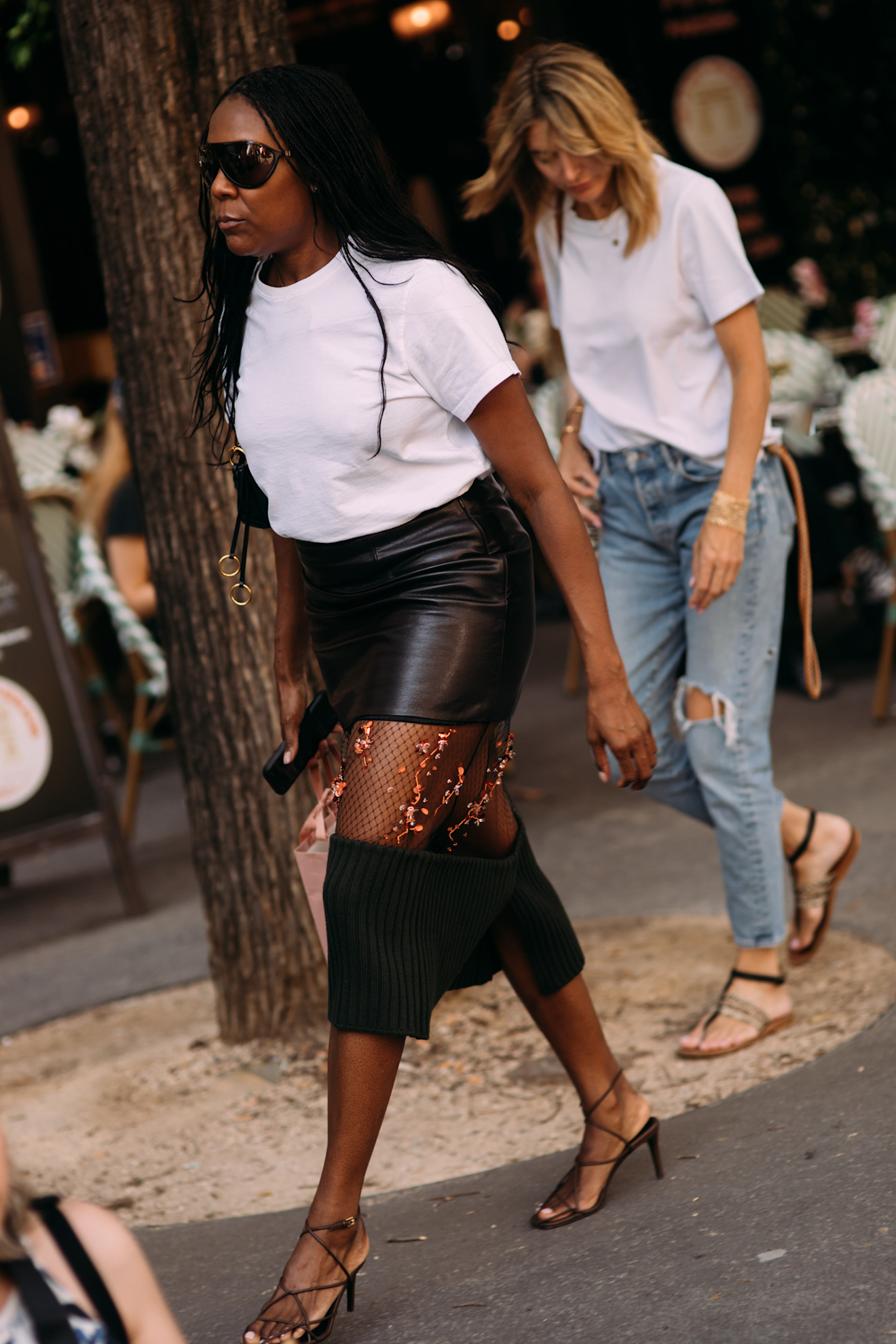 Guest wearing a white T-shirt with a Prada tiered skirt and strappy heels in Paris.