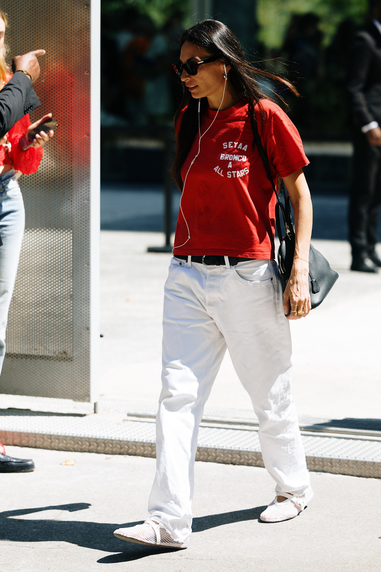 A guest wearing a red T-shirt with white jeans and Alaïa flats in Paris.