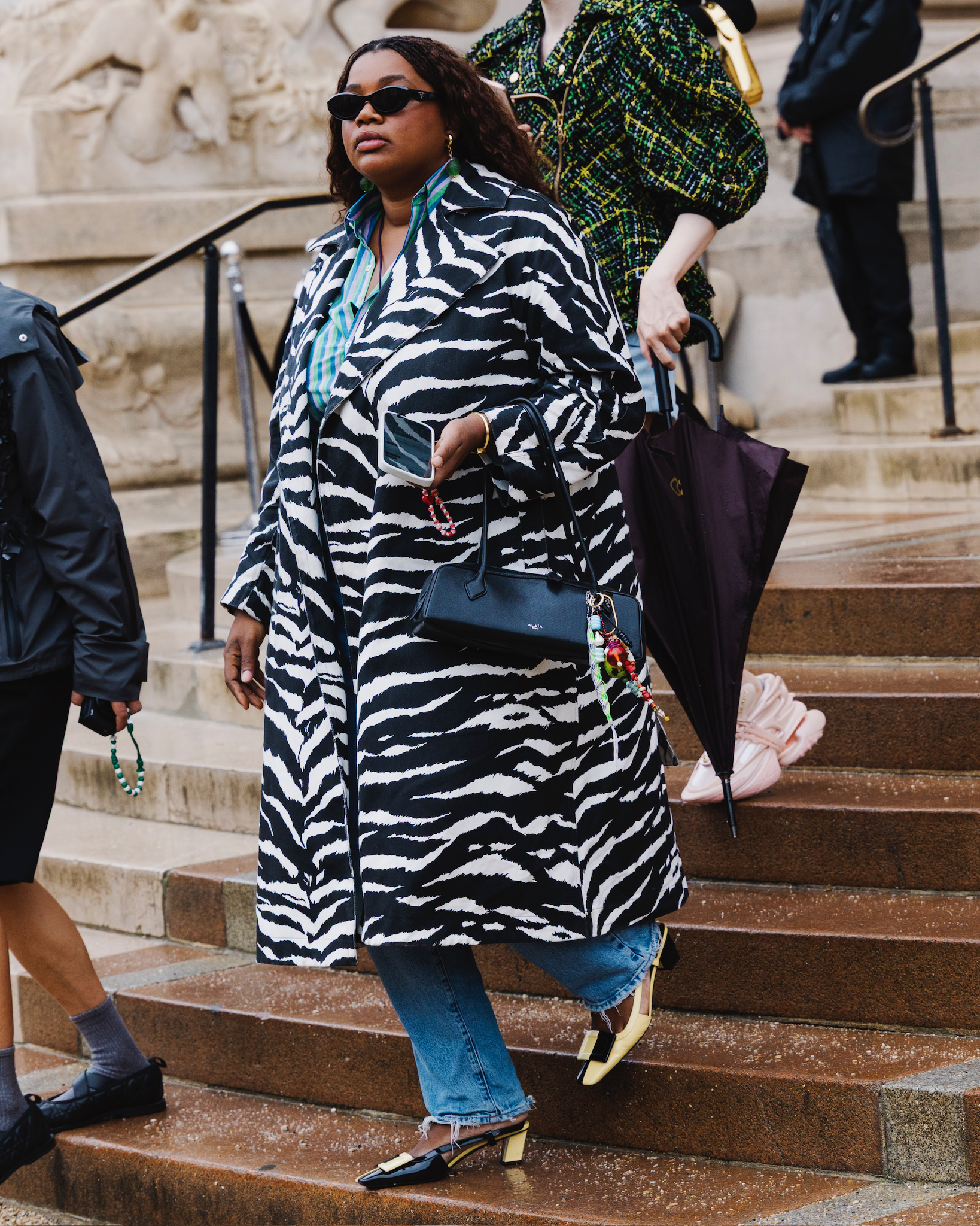 Gabriela Karefa Johnson wearing a zebra print coat, Alaïa bag, and jeans to the Schiaparelli show in Paris.